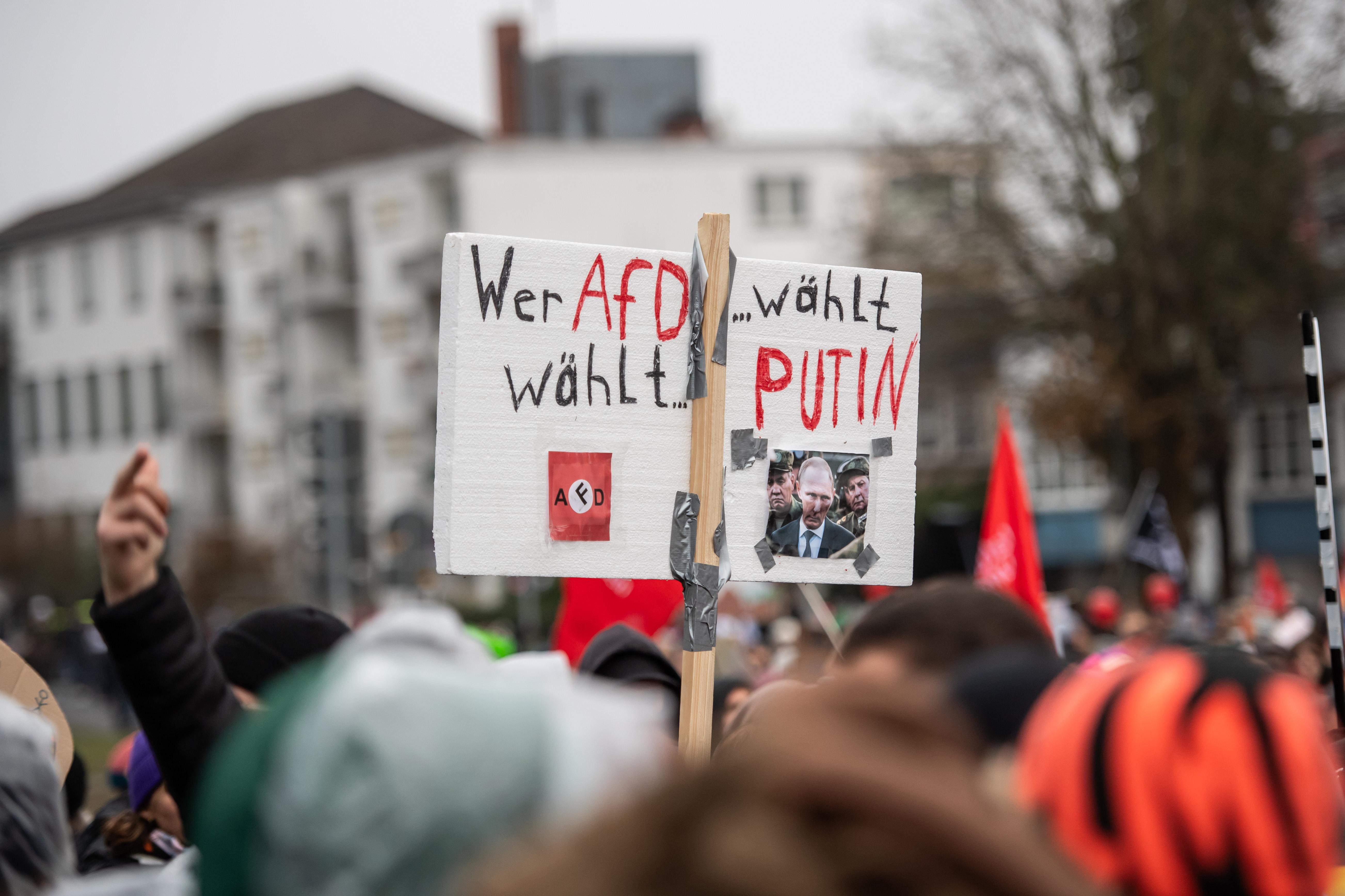 GIESSEN, GERMANY - NOVEMBER 29: A protester holds a sign that says ''who votes for AfD, votes for Putin'' outside the Messe trade fair hall prior to the founding congress of the new youth wing of the far-right Alternative for Germany (AfD) political party on November 29, 2025 in Giessen, Germany. Tens of thousands of protesters are expected to take part in demonstrations in Giessen against the congress, with some seeking to block access to the venue for congress participants. (Photo by Hesham Elsherif/Getty Images)