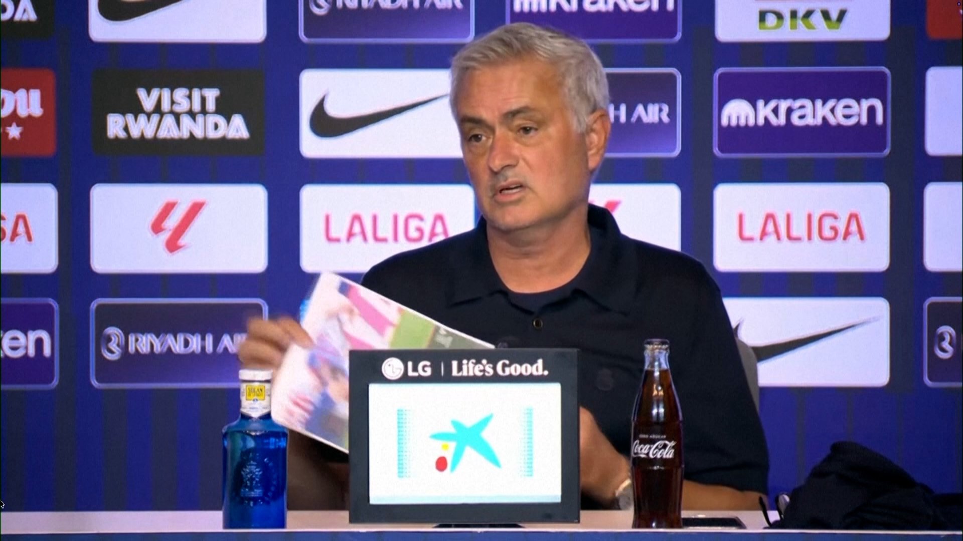 Jose Mourinho holding up two images of 'clear red cards'