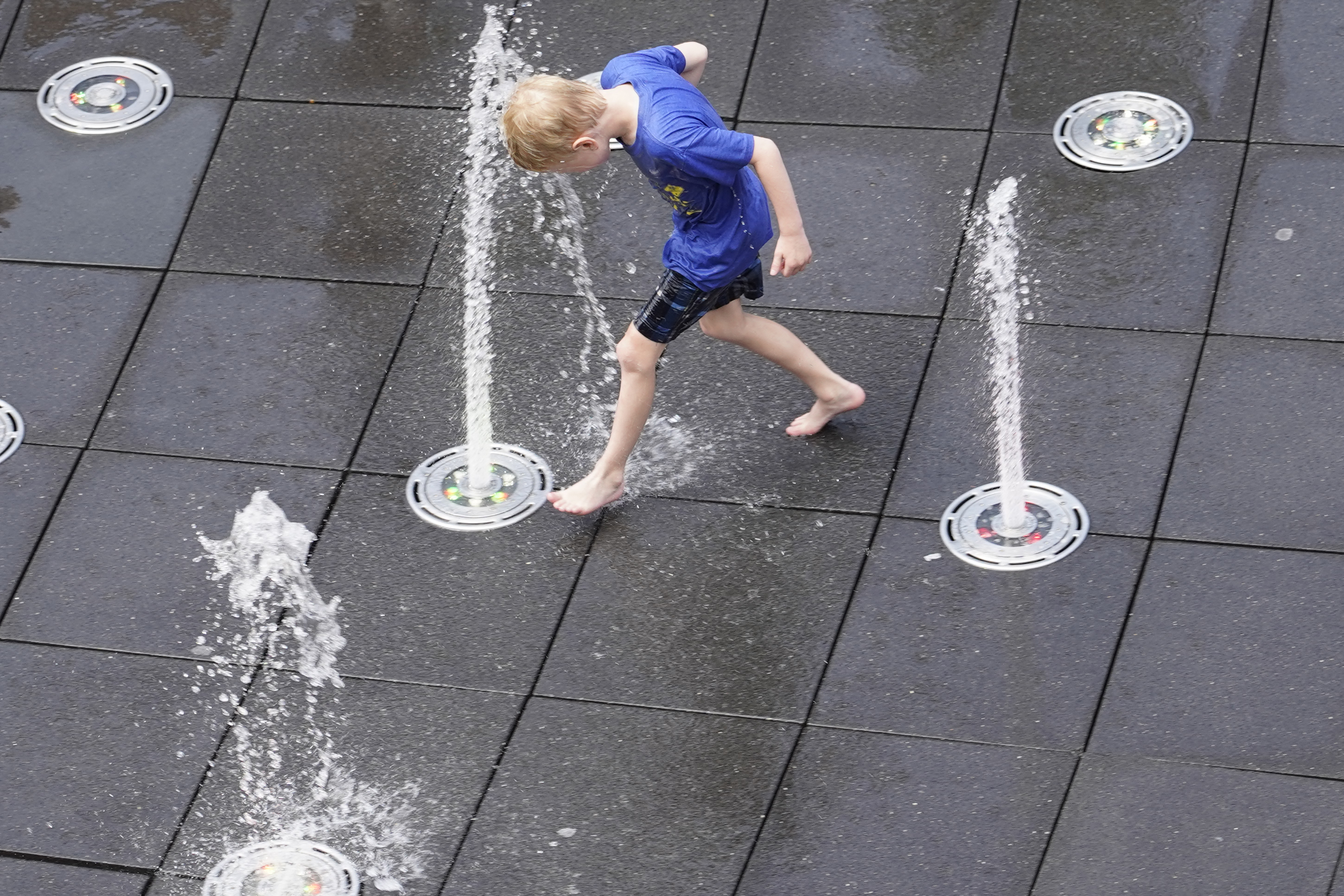 Jul 23, 2025; Chicago, Illinois, USA; A boy tries to stay cool on a day with extreme heat before a game between the Chicago Cubs and the Kansas City Royals at Wrigley Field. Mandatory Credit: David Banks-Imagn Images