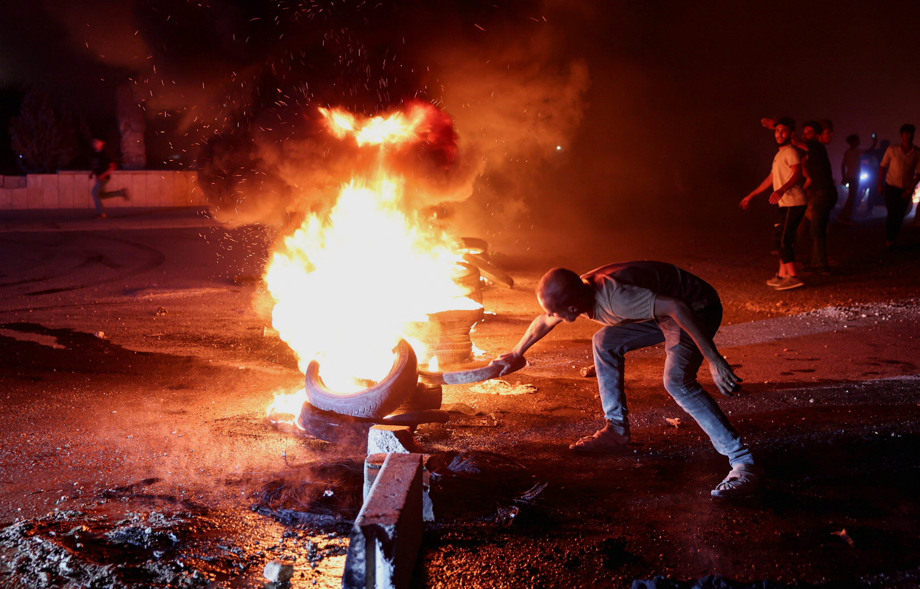 A protester burns tyres on the highway between Aleppo and Turkiye to protest against fuel price increases in Syria on September 13, 2026