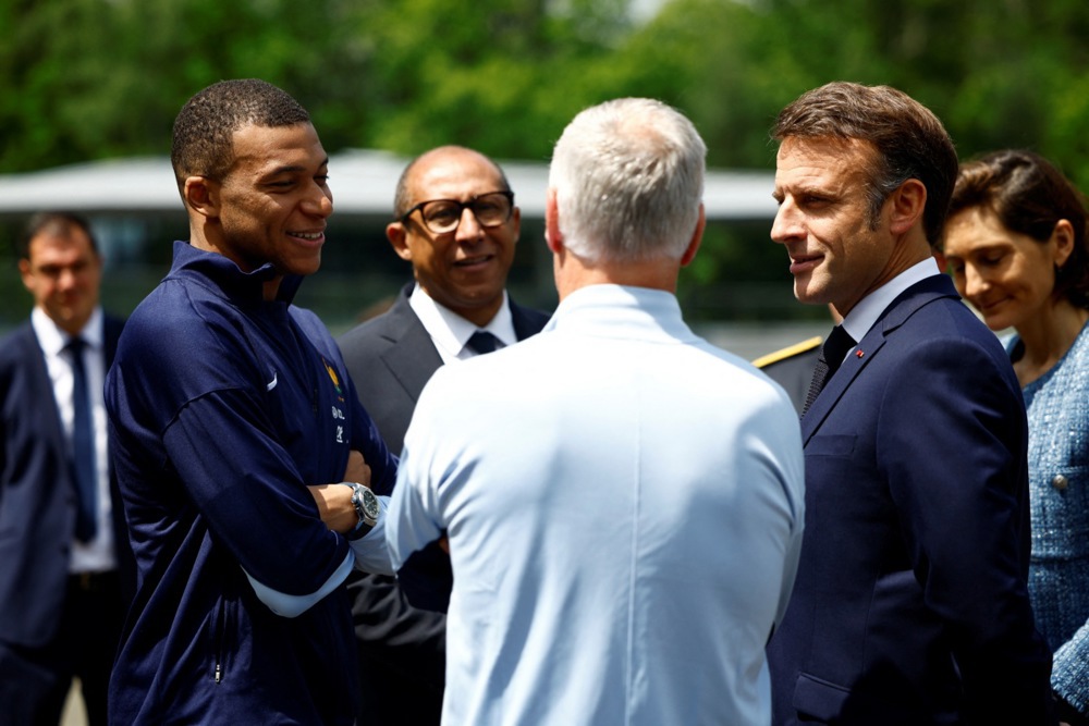 French President Emmanuel Macron (2R) talks with French soccer player Kylian Mbappe (L), French national football team head coach Didier Deschamps (C), French Football Federation President Philippe Diallo (2L)