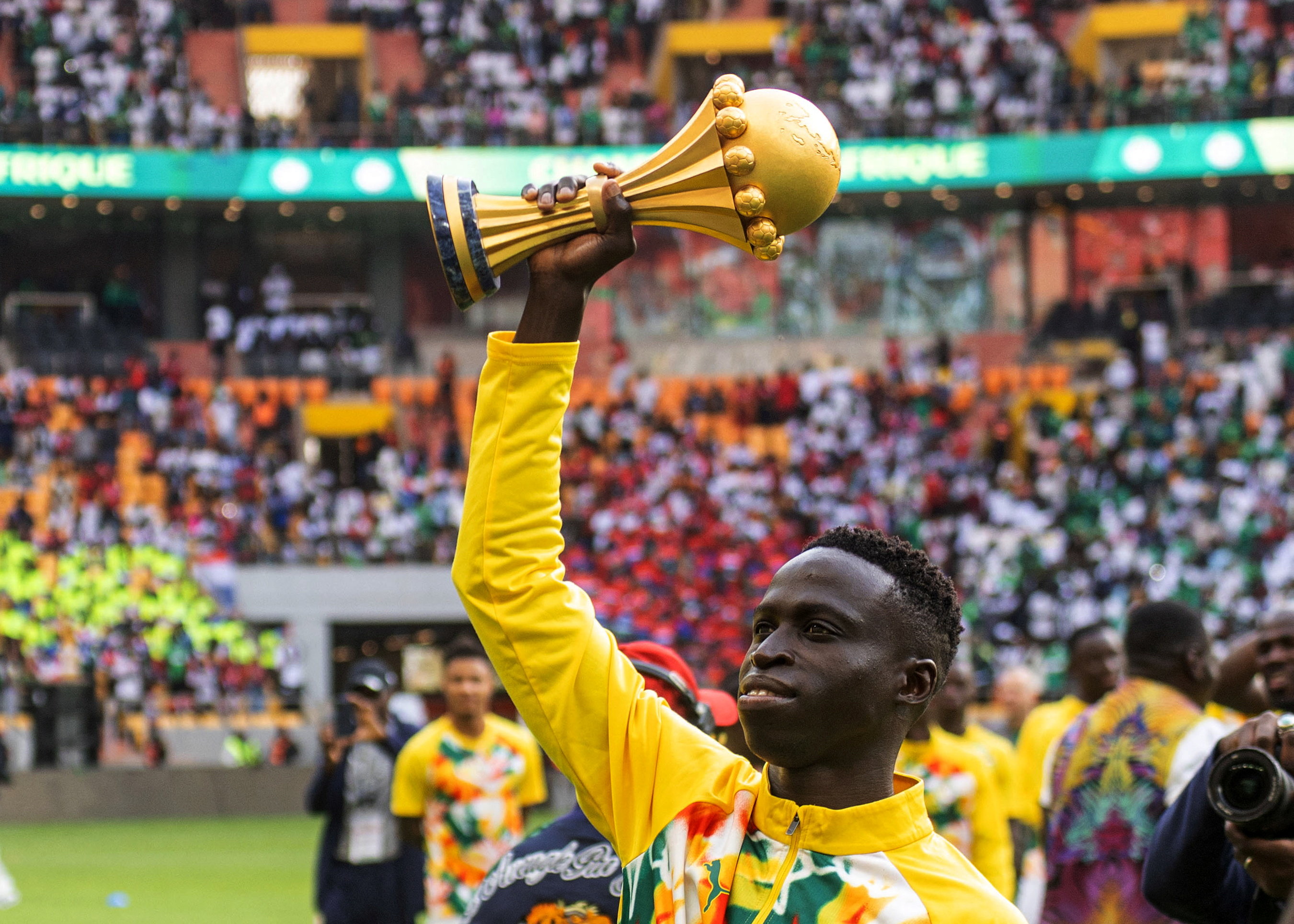 Senegal's Krepin Diatta celebrates as he holds the AFCON trophy.