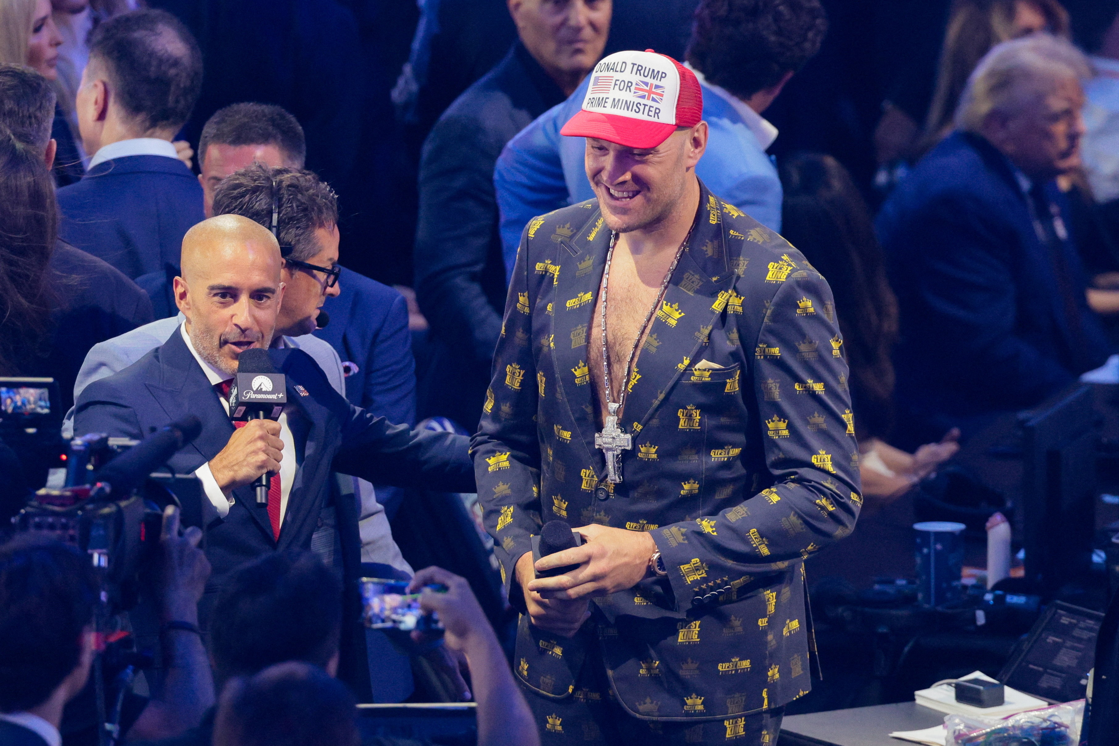 Boxer Tyson Fury wears a cap reading "Donald Trump for Prime Minister" as U.S. President Donald Trump sits in the background during UFC Freedom 250 on the South Lawn of the White House in Washington, D.C., U.S., June 14, 2026. REUTERS/Evan Vucci