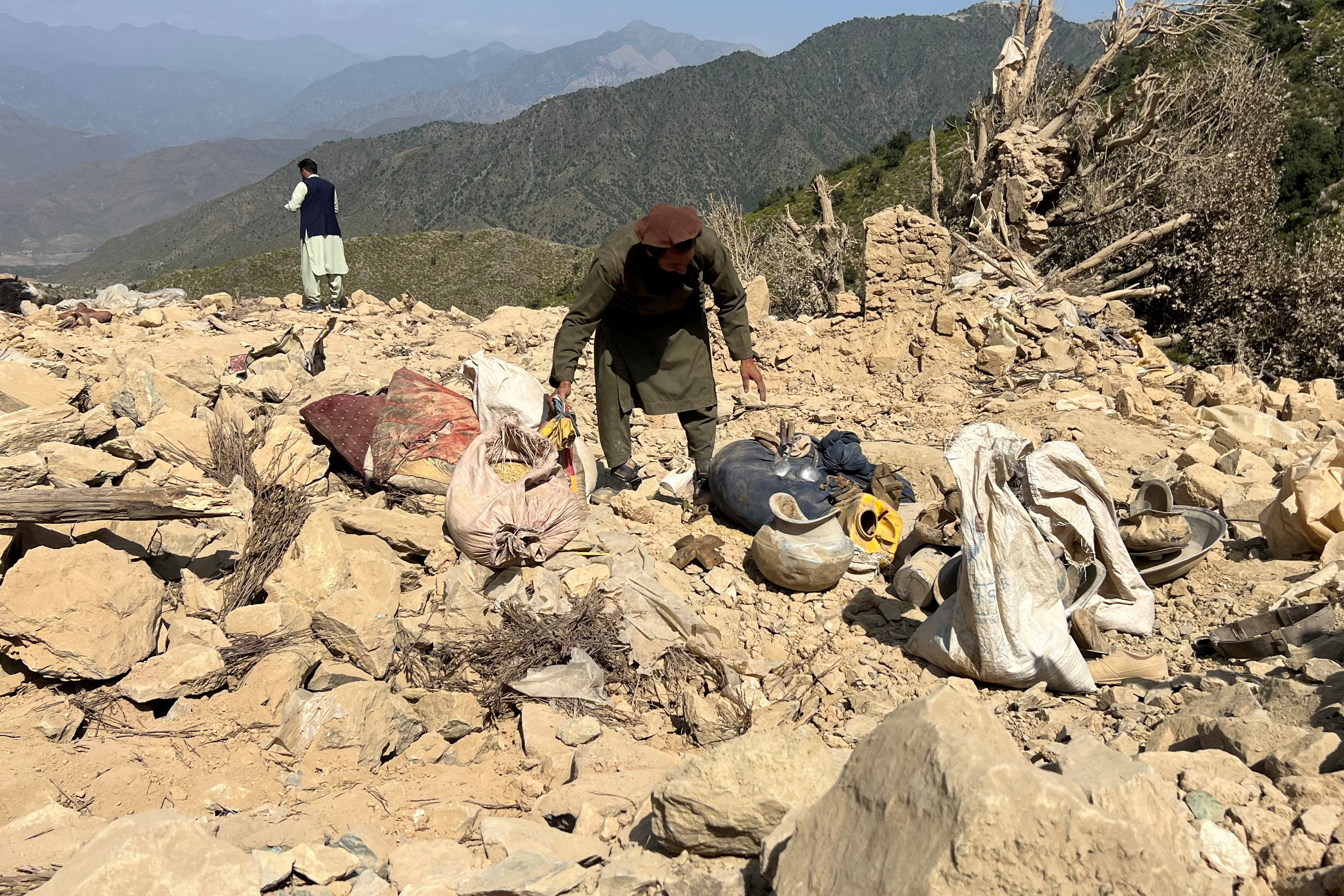 A man salvages his belongings from the debris of his house, which was damaged in an air attack in Shultan, Kunar, Afghanistan