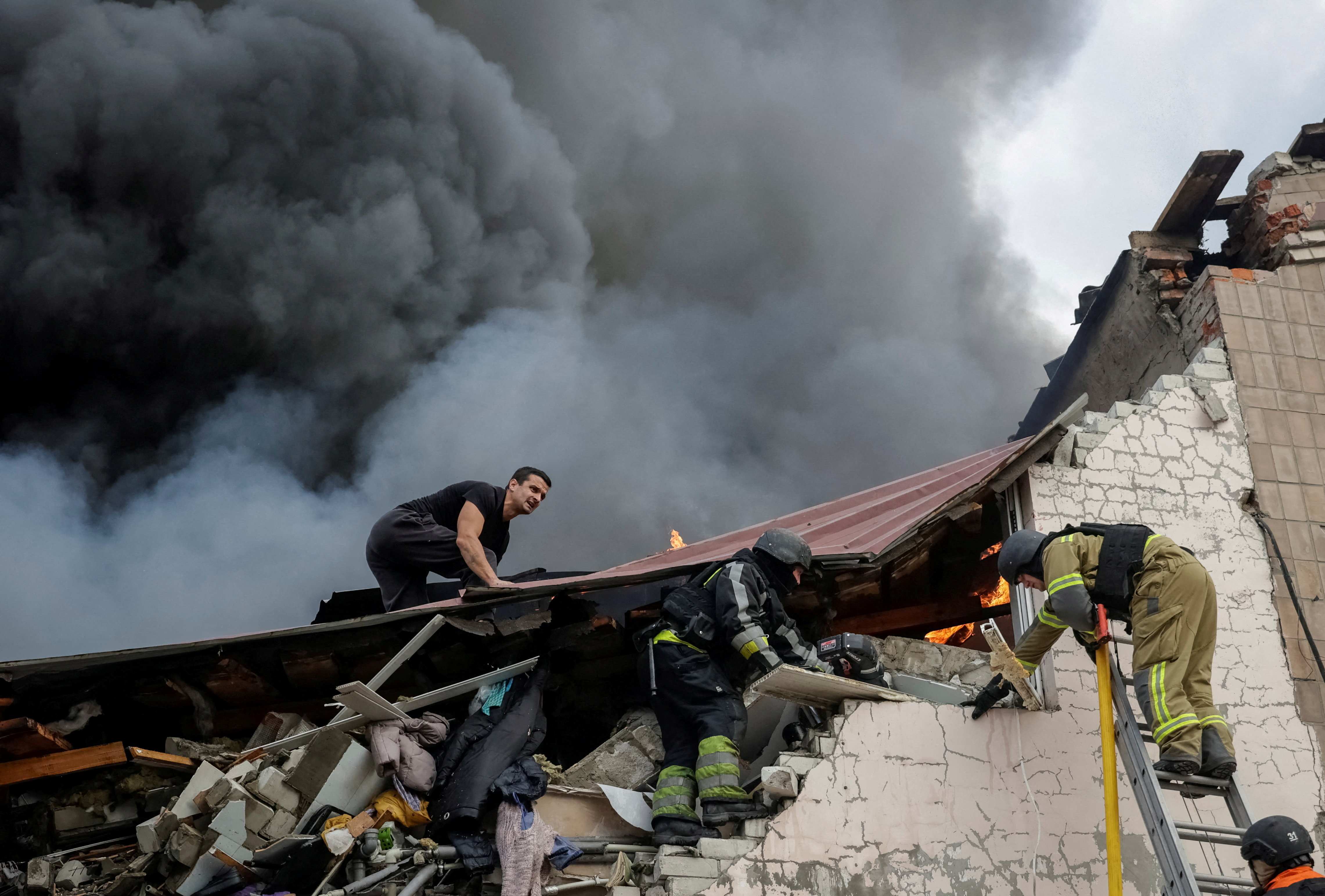 Rescuers work at the site of a damaged building.