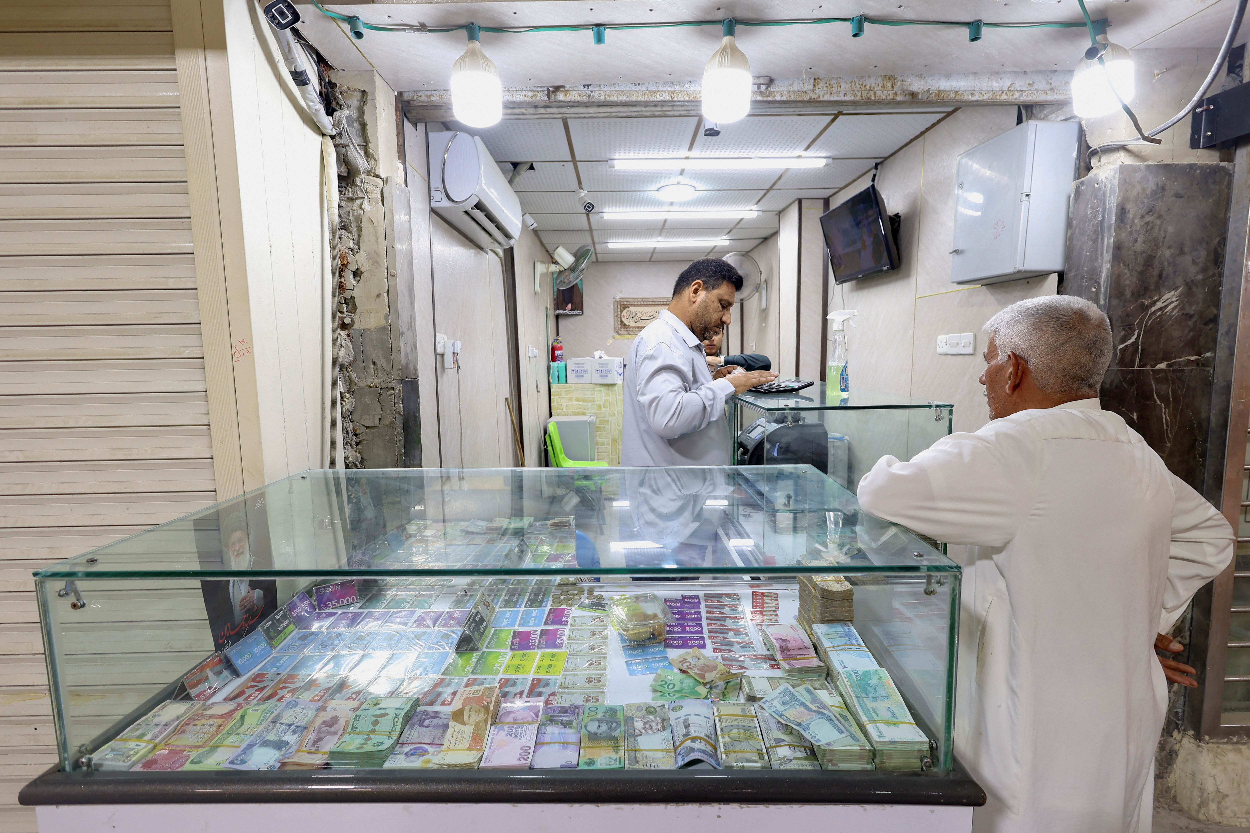 A customer stands at a currency exchange shop in Najaf, Iraq, October 7, 2026 [Alaa Al-Marjani/ Reuters]