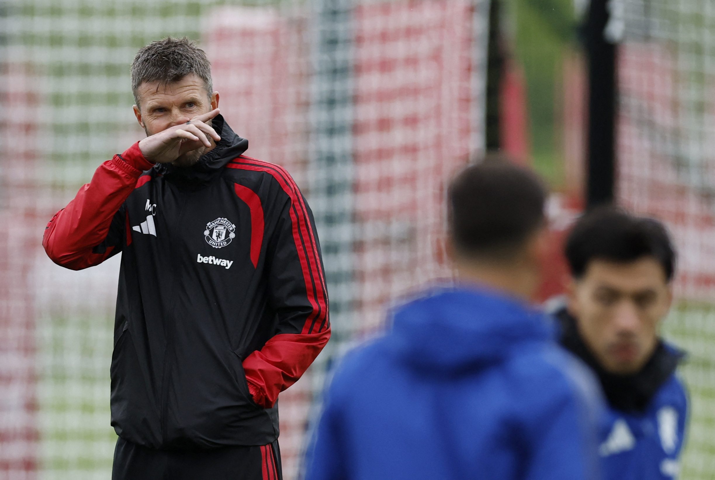 Manchester United manager Michael Carrick looks on as Lisandro Martinez, right, trains