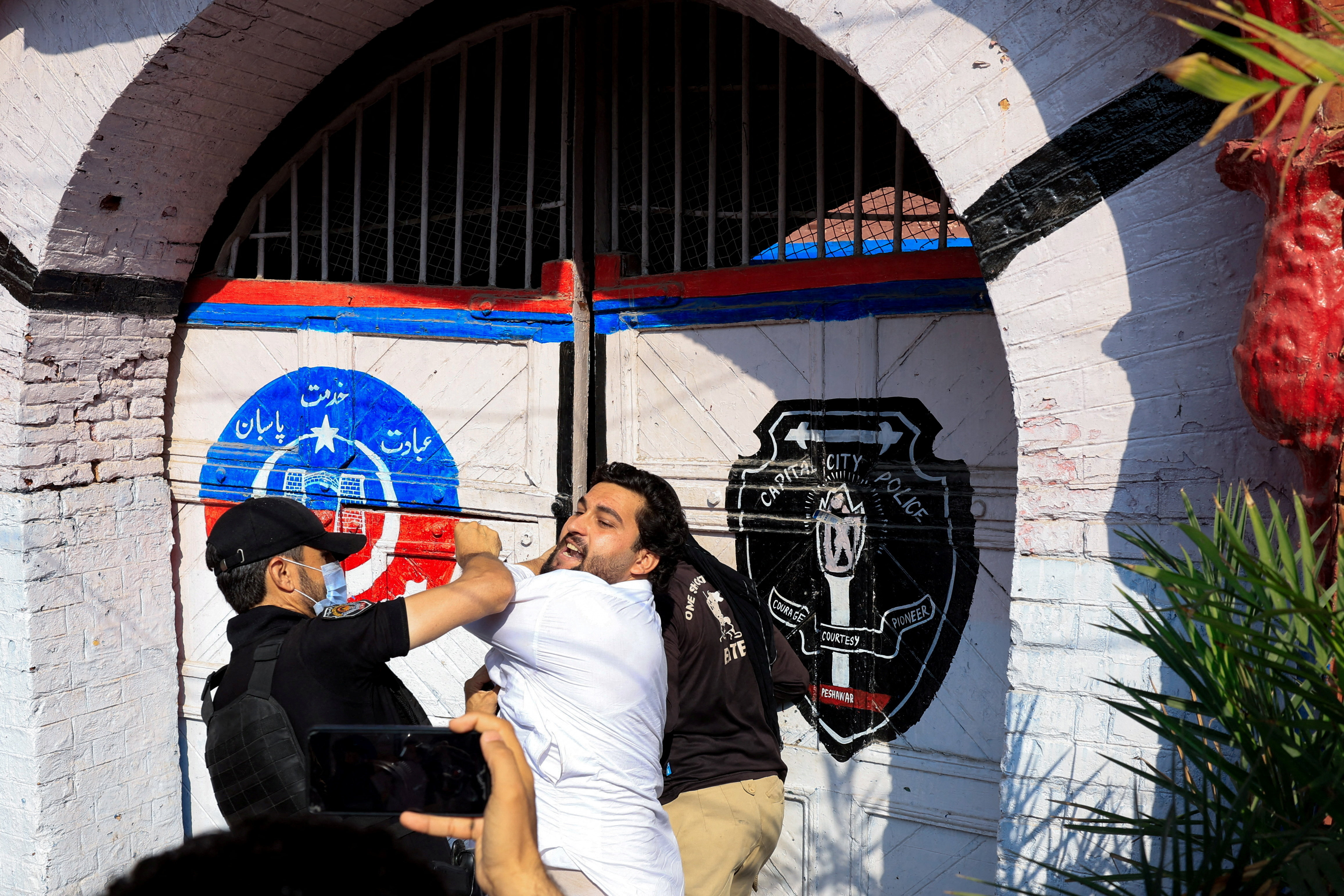 Police officers arrest a protester.