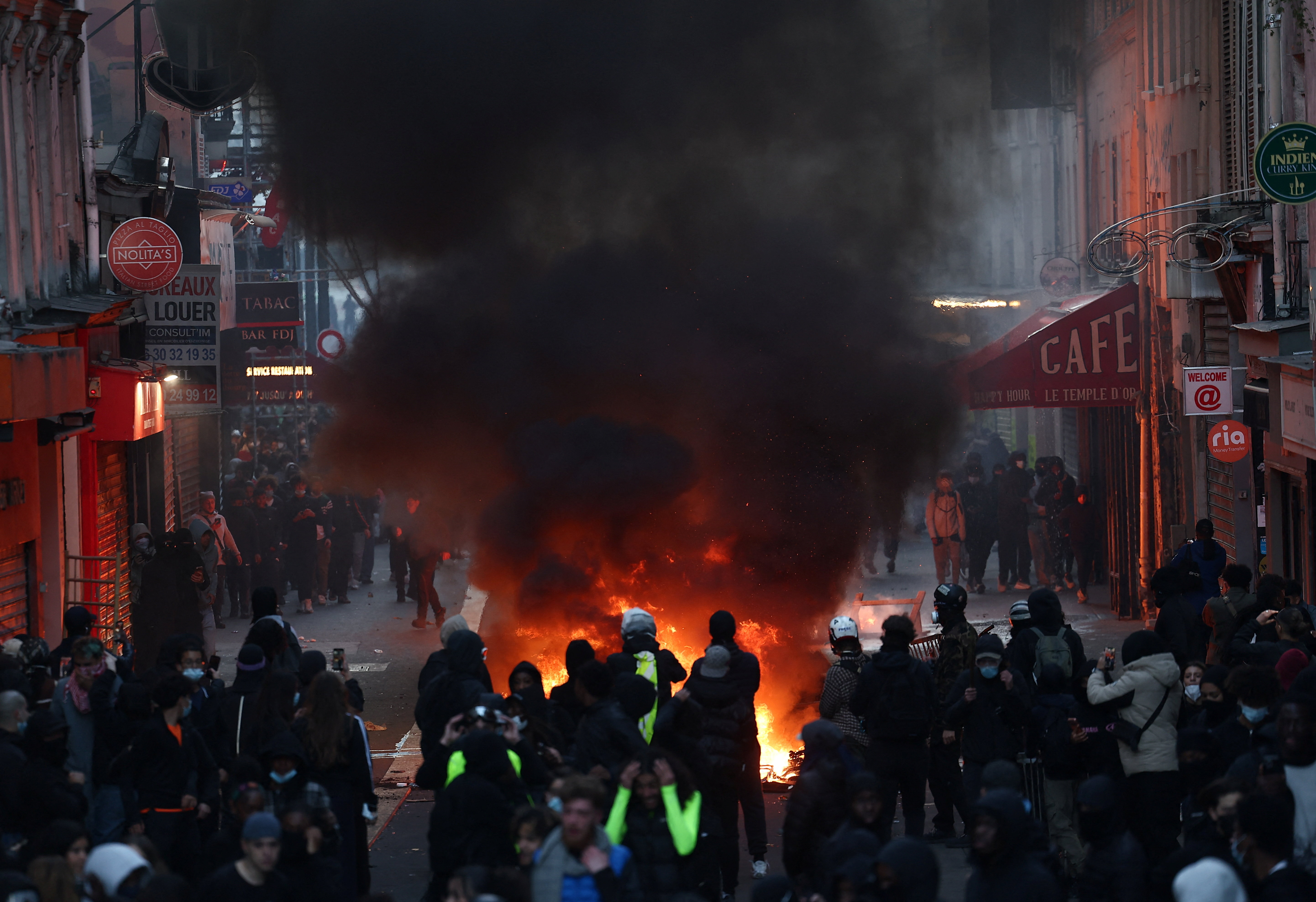 Flames and smoke rise during demonstrations in Paris, France, on Sunday [Abdul Saboor/Reuters]