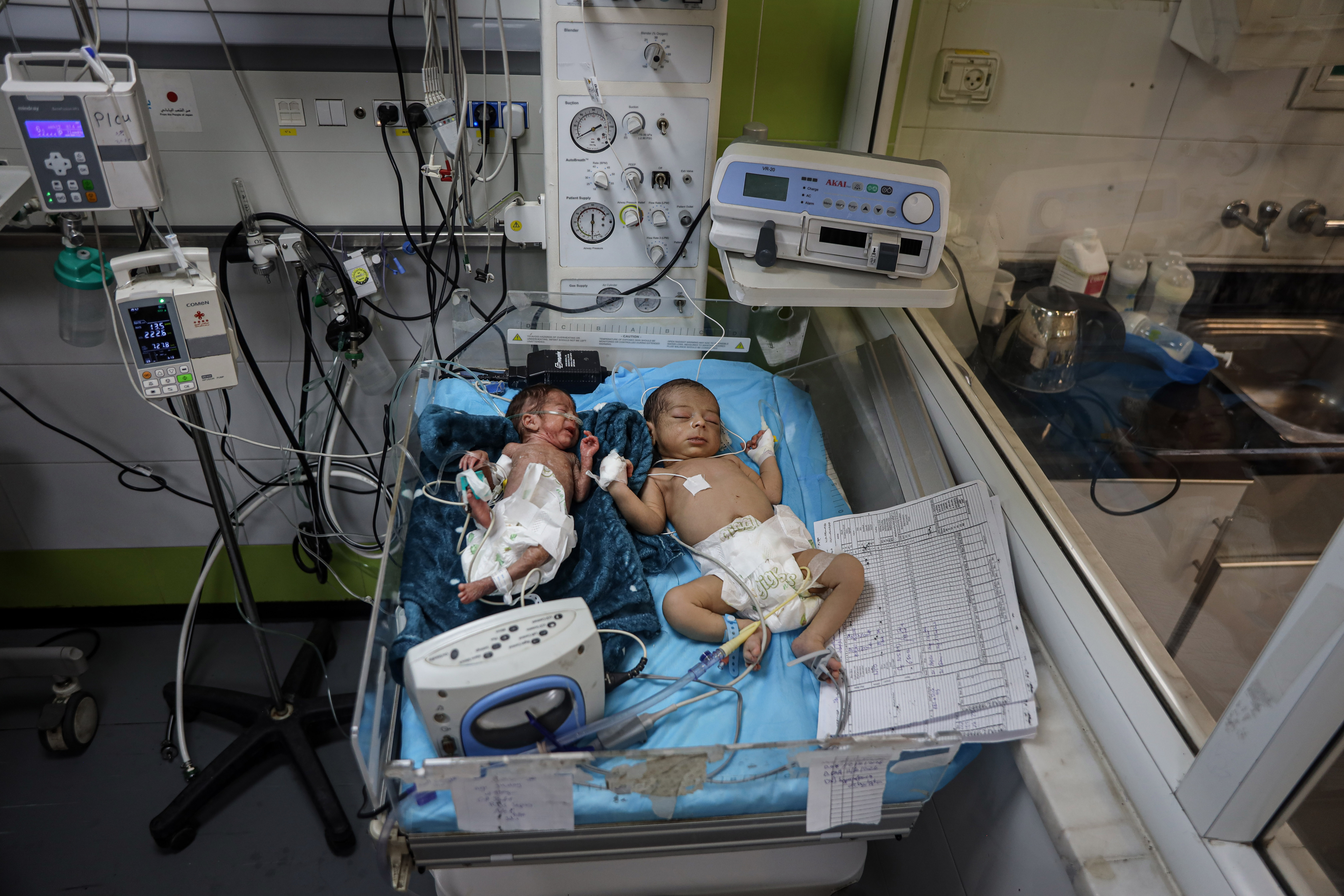 A shortage of incubators at Nasser Medical Complex in Khan Younis, southern Gaza, has forced medical staff to place two babies in one incubator amid overcrowding. [Abdelhakim Abu Riash/ Al Jazeera]