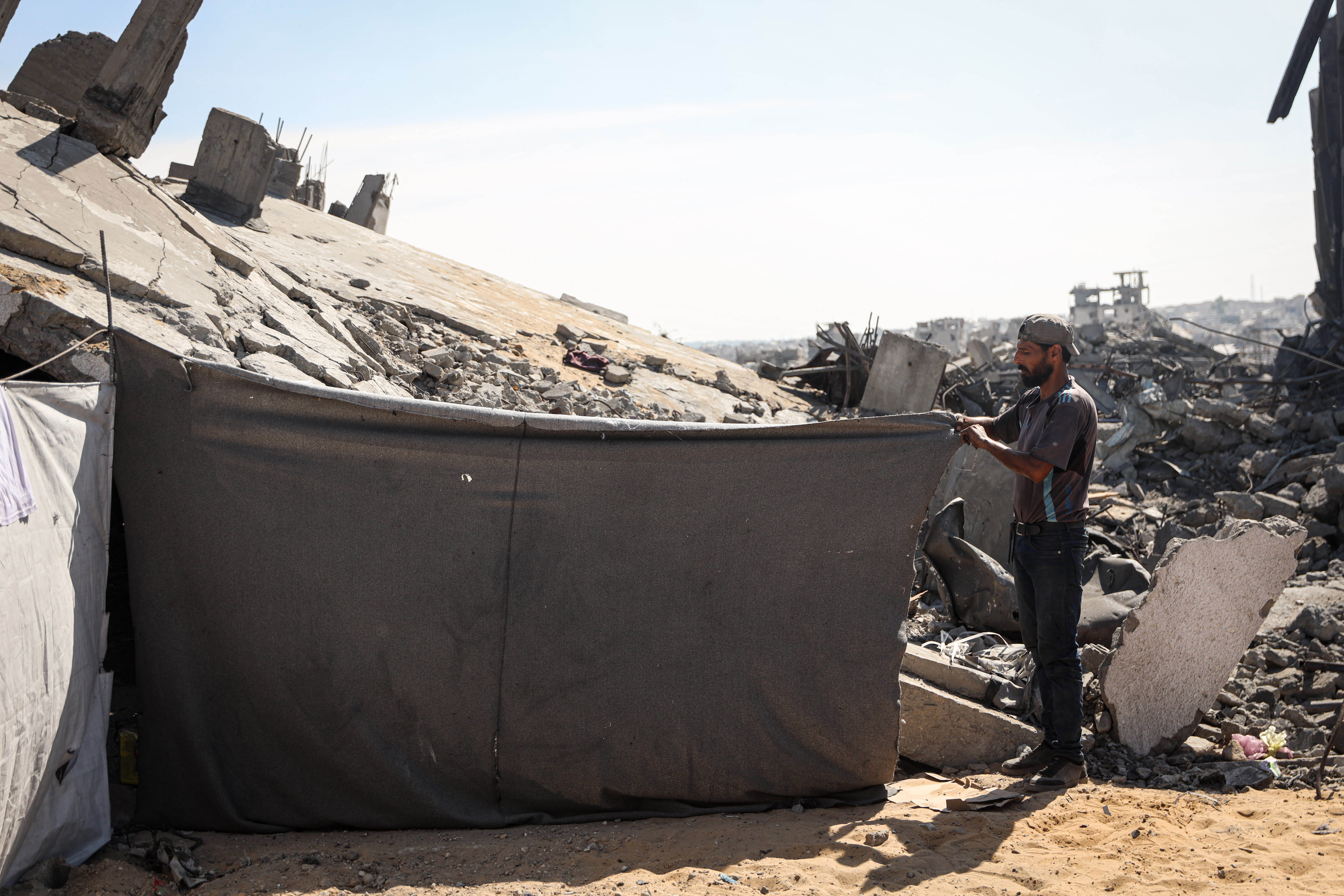 Displaced Palestinian Mahmoud Harzeen pitches a tent in Shujaiya, east of Gaza City, as Israel advances the Yellow Line. [Abdelhakim Abu Riash/Al Jazeera]