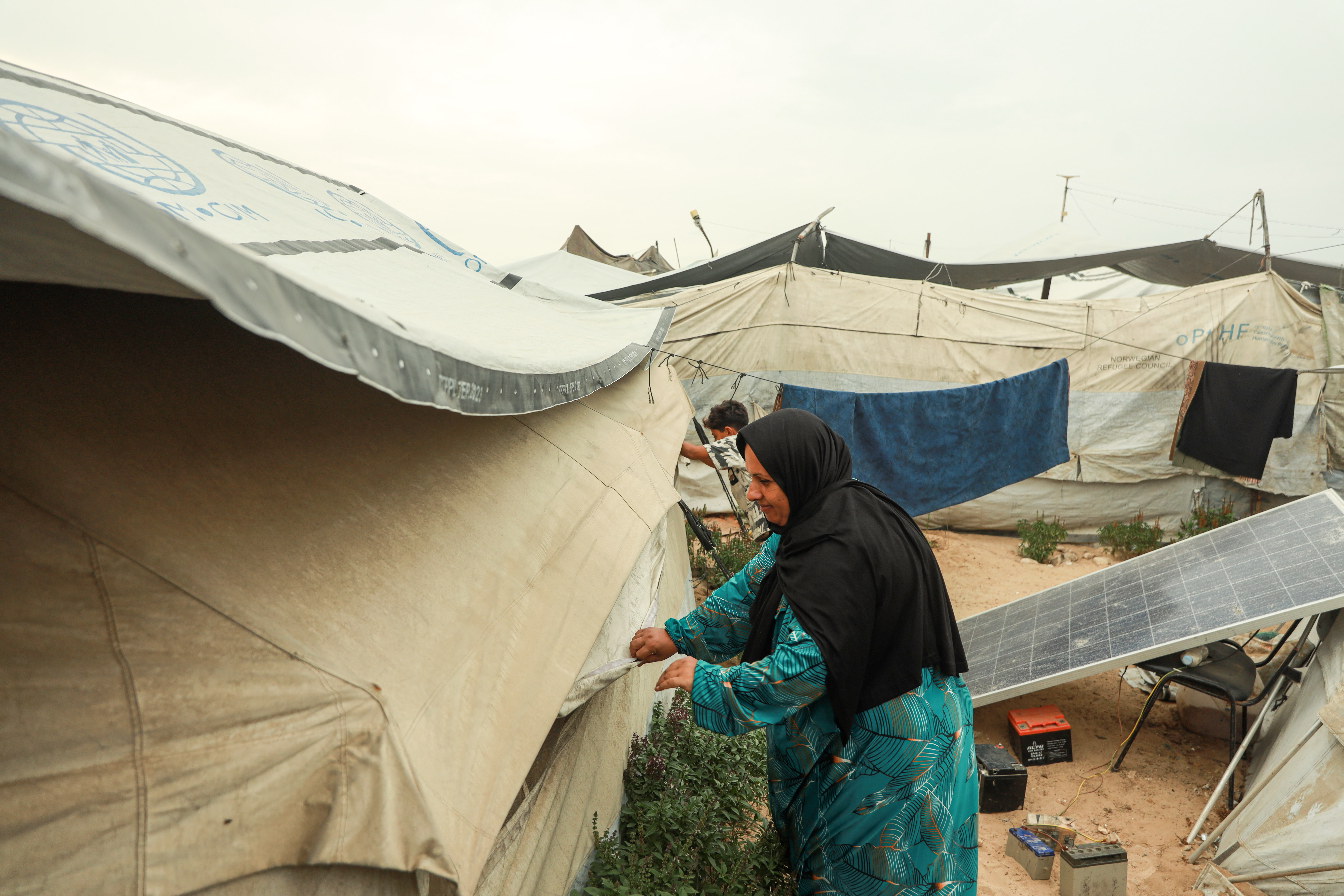 Khitam Salman prepares her family’s damaged tents for another winter in Gaza