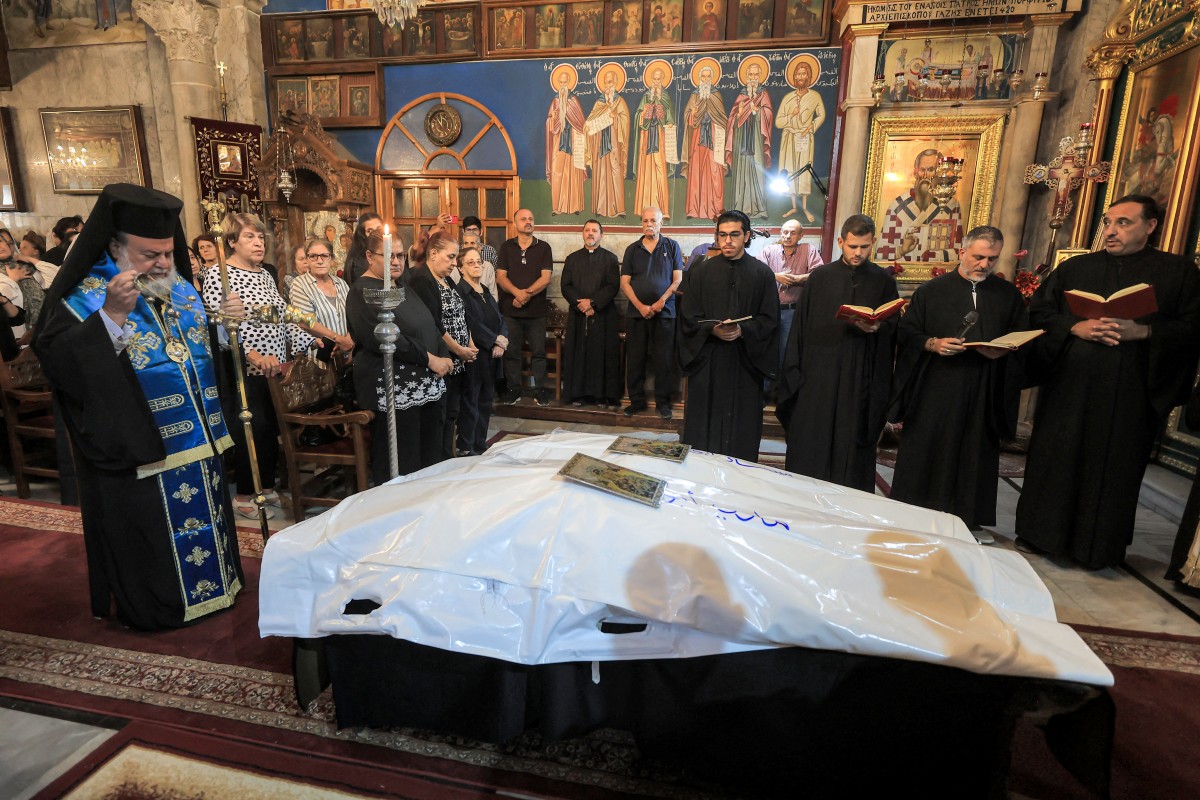 Archbishop Alexios of Tiberias censes during the funeral of Maysaa Abu Daoud and her daughter Mary al-Najjar