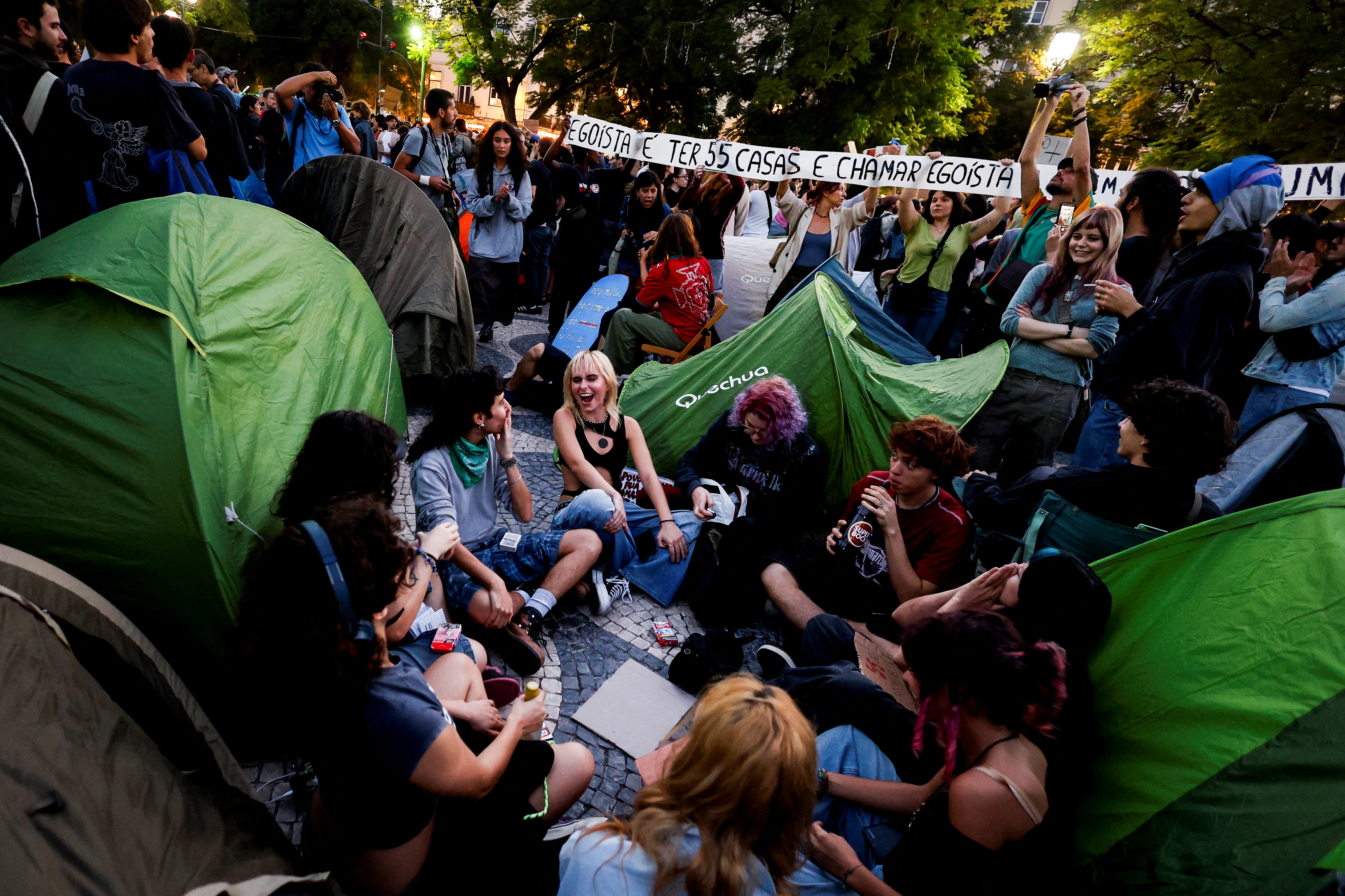Demonstrators sit amid 40 tents set up to protest against housing shortage, soaring rents and low wages on Rossio square in central Lisbon on October 17, 2026. Thousands of people marched on October 17, 2026 through the centre of Lisbon at the call of the CGTP trade union to protest against increasingly difficult living conditions. The slogans and demands focus mainly on higher wages and pensions, as well as protests against the rising cost of housing and fuel. [Filipe Amorim/AFP]