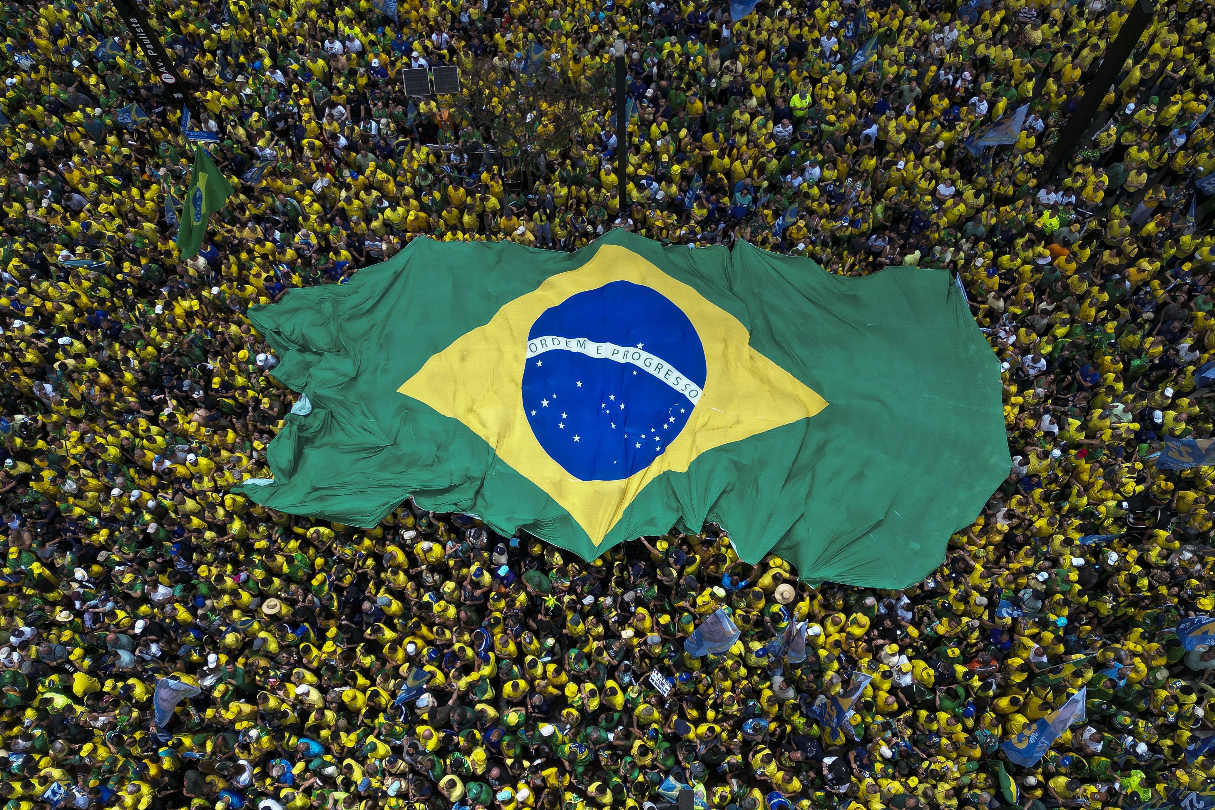Supporters of Brazil’s right-wing senator and Liberal Party presidential candidate, Flavio Bolsonaro, hold a giant Brazilian flag during a rally on Paulista Avenue in Sao Paulo, Brazil, on October 18, 2026