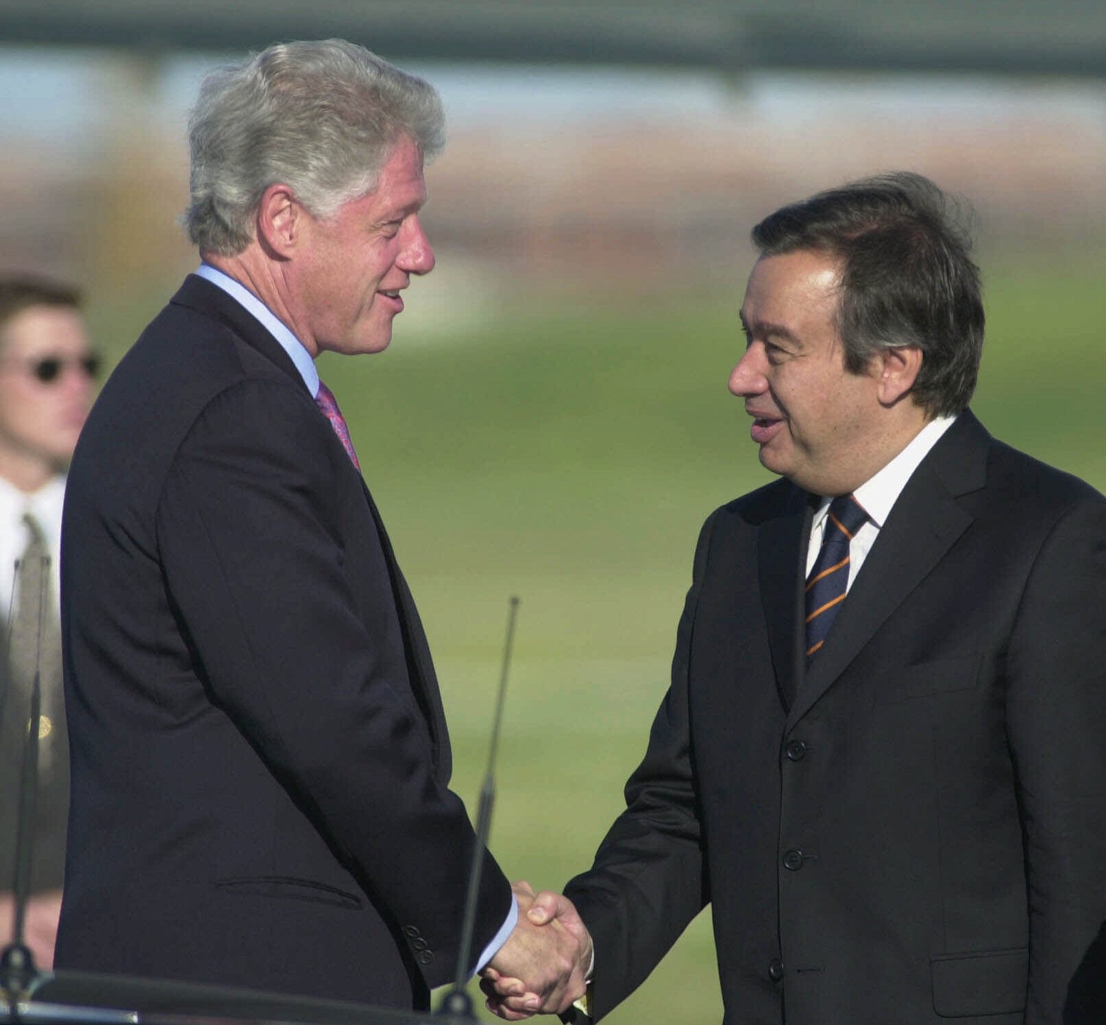 U.S. President Bill Clinton shakes hands with Portuguese Prime Minister Antonio Guterres on the tarmac of Lisbon's airport upon arriving in Portugal for a three-day official visit on May 30, 2000 [Armando Franca/AP]