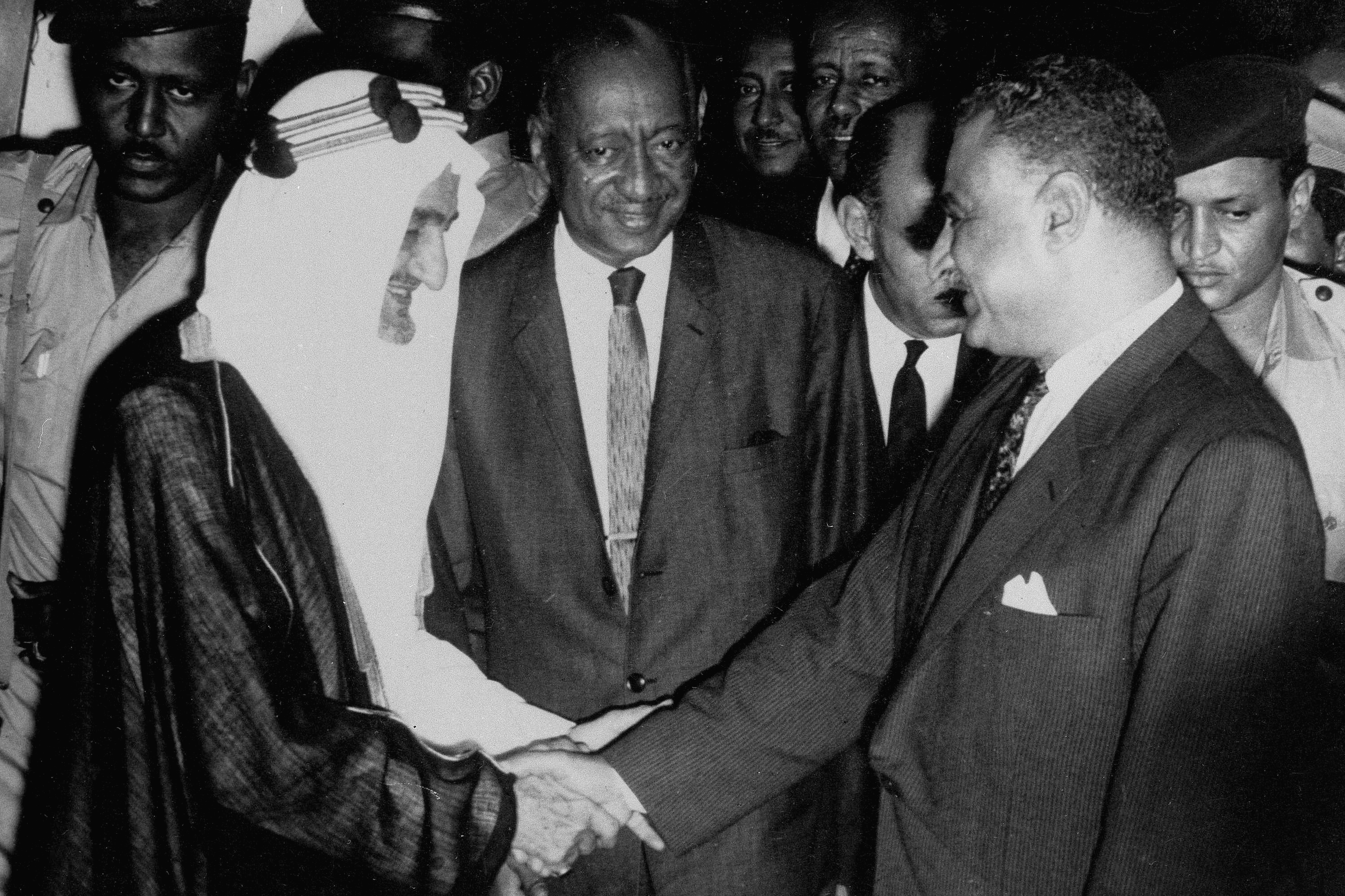 Saudi King Faisal and Egyptian President Nasser shake hands in Khartoum, Sudan, in the presence of Sudanese Prime Minister Muhammad Ahmad Mahgoub, in the centre, August 31, 1967, after an earlier meeting in which the two agreed to a formula to end their participation in the Yemen civil war on opposing sides [AP Photo]