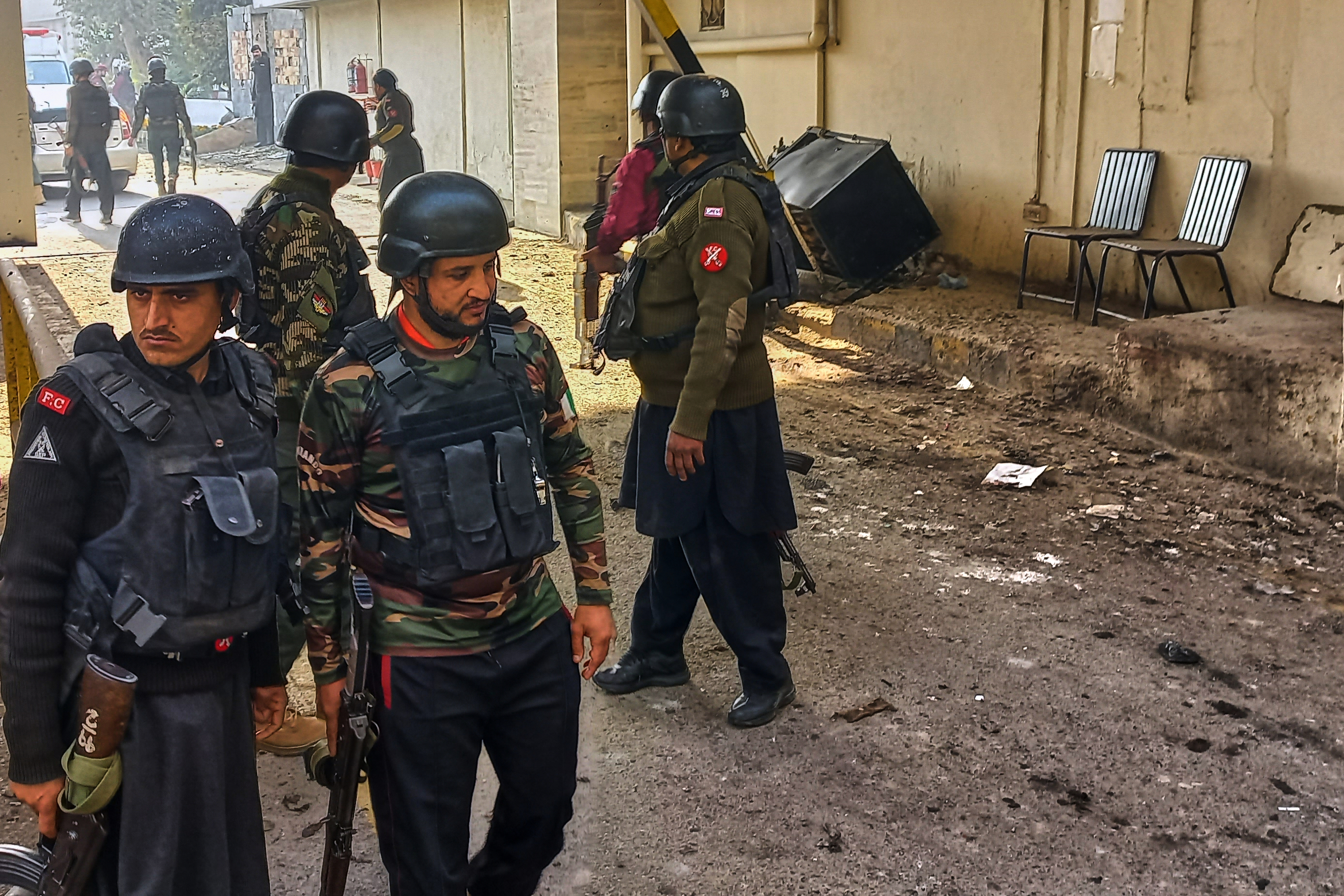 Security officials gather at the site of a suicide bombing at the main gate of headquarters of the Federal Constabulary (FC), in Peshawar, Pakistan, Monday, Nov. 24, 2025. (AP Photo/Muhammad Zubair)