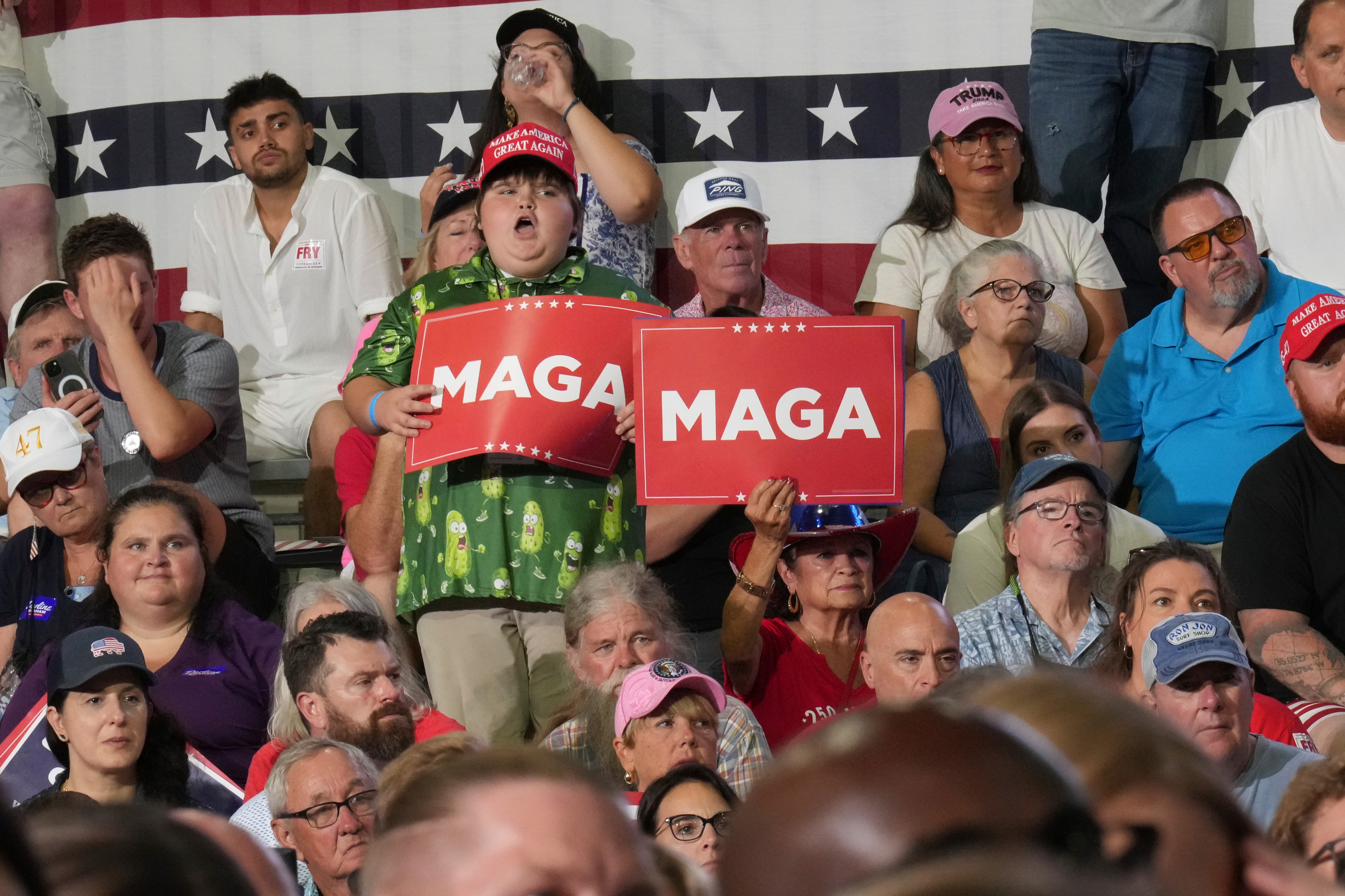 Attendees hold MAGA signs as US President Donald Trump speaks at a campaign rally in Myrtle Beach, South Carolina, [File: Jacquelyn Martin/AP Photo]