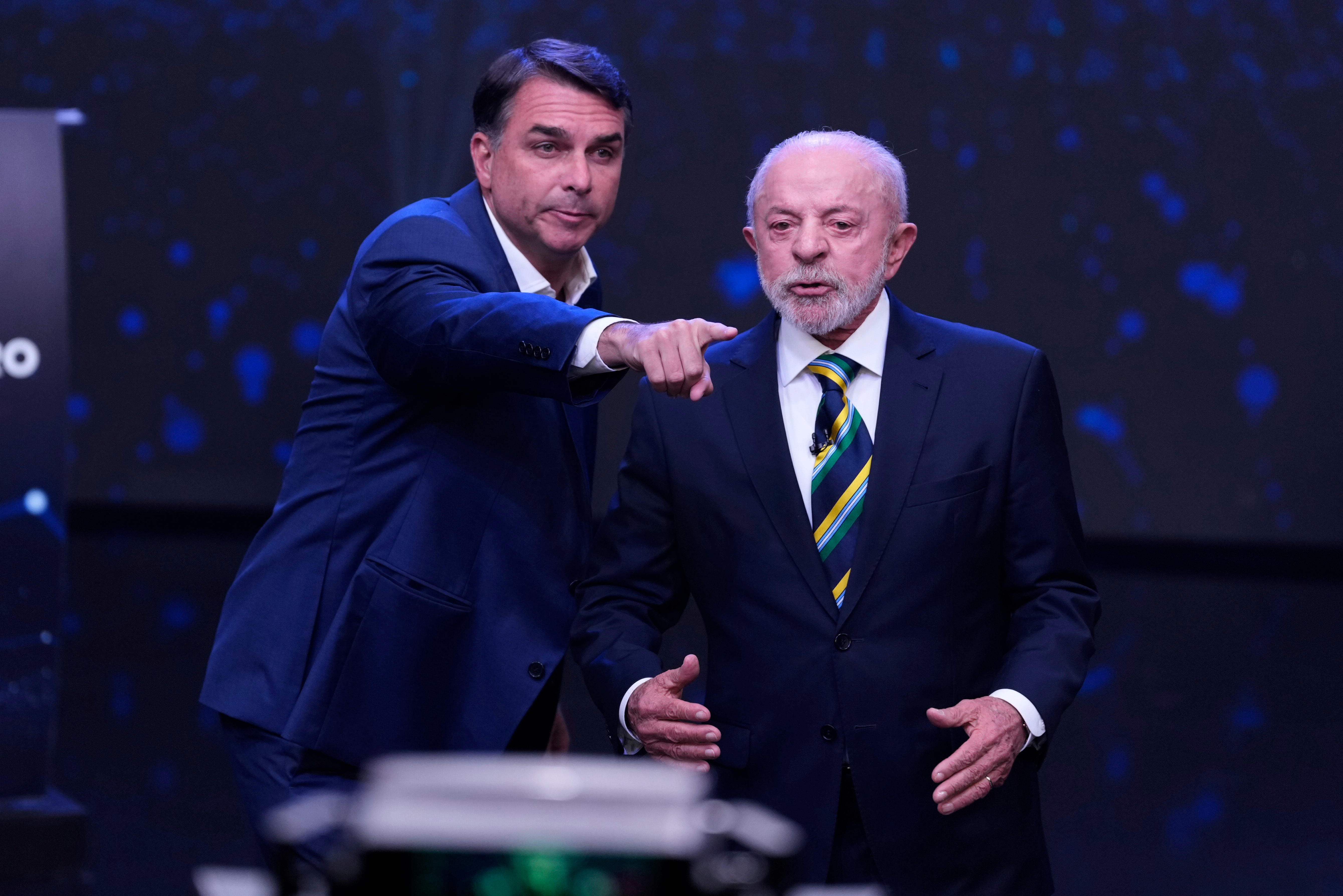 Opposition presidential candidate Sen. Flavio Bolsonaro, left, points as Brazilian President Luiz Inacio Lula da Silva stands beside him during a televised presidential debate one week before the presidential runoff election in Sao Paulo, Brazil, Sunday, Oct. 18, 2026. (AP Photo/Andre Penner)