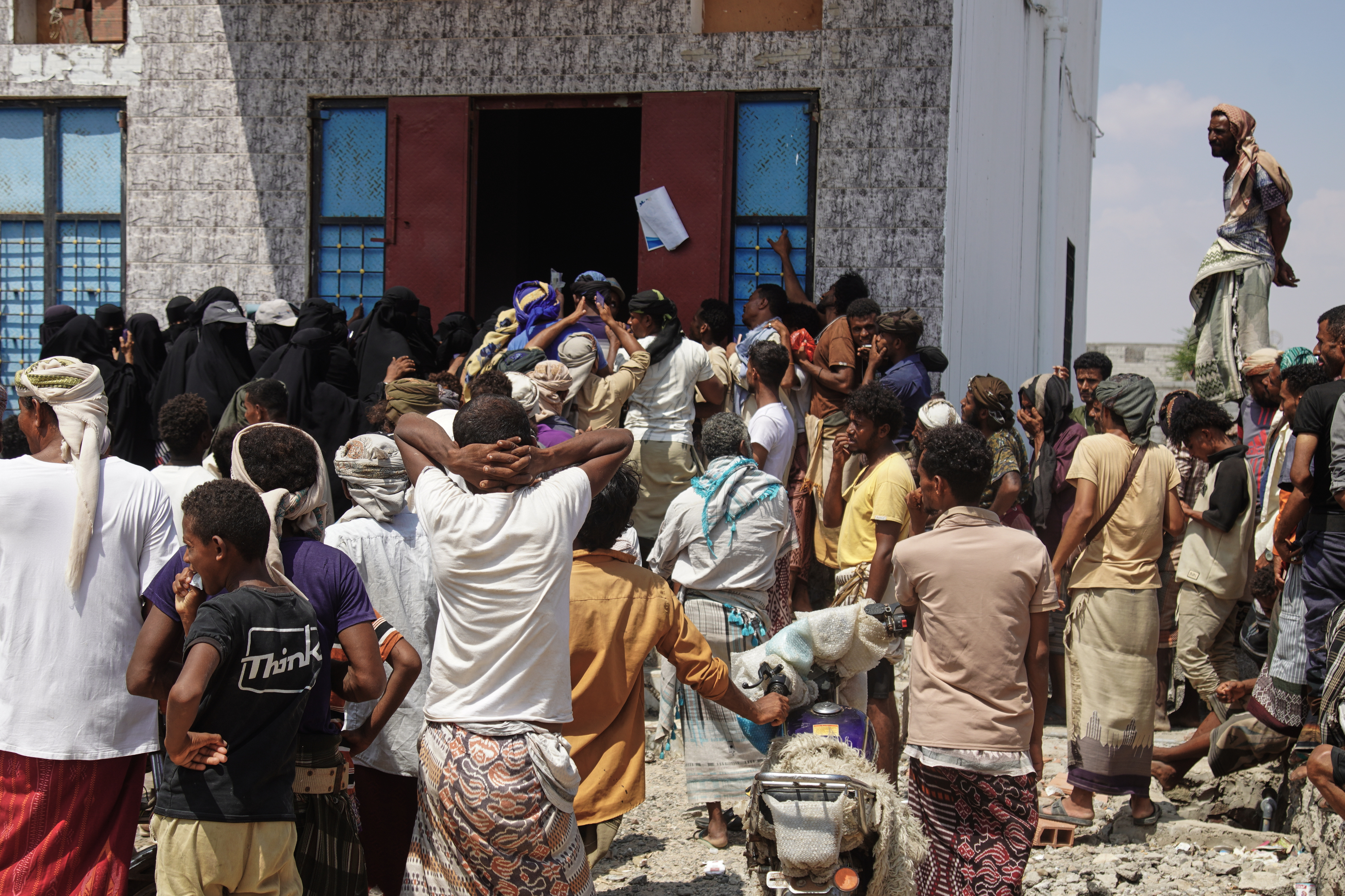 Yemenis displaced by fighting in Taiz gather to receive food aid in the Salah al-Din area on the outskirts of Aden, Yemen, Sunday, Oct. 25, 2026. (AP Photo/Abdulnasser Alseddik)