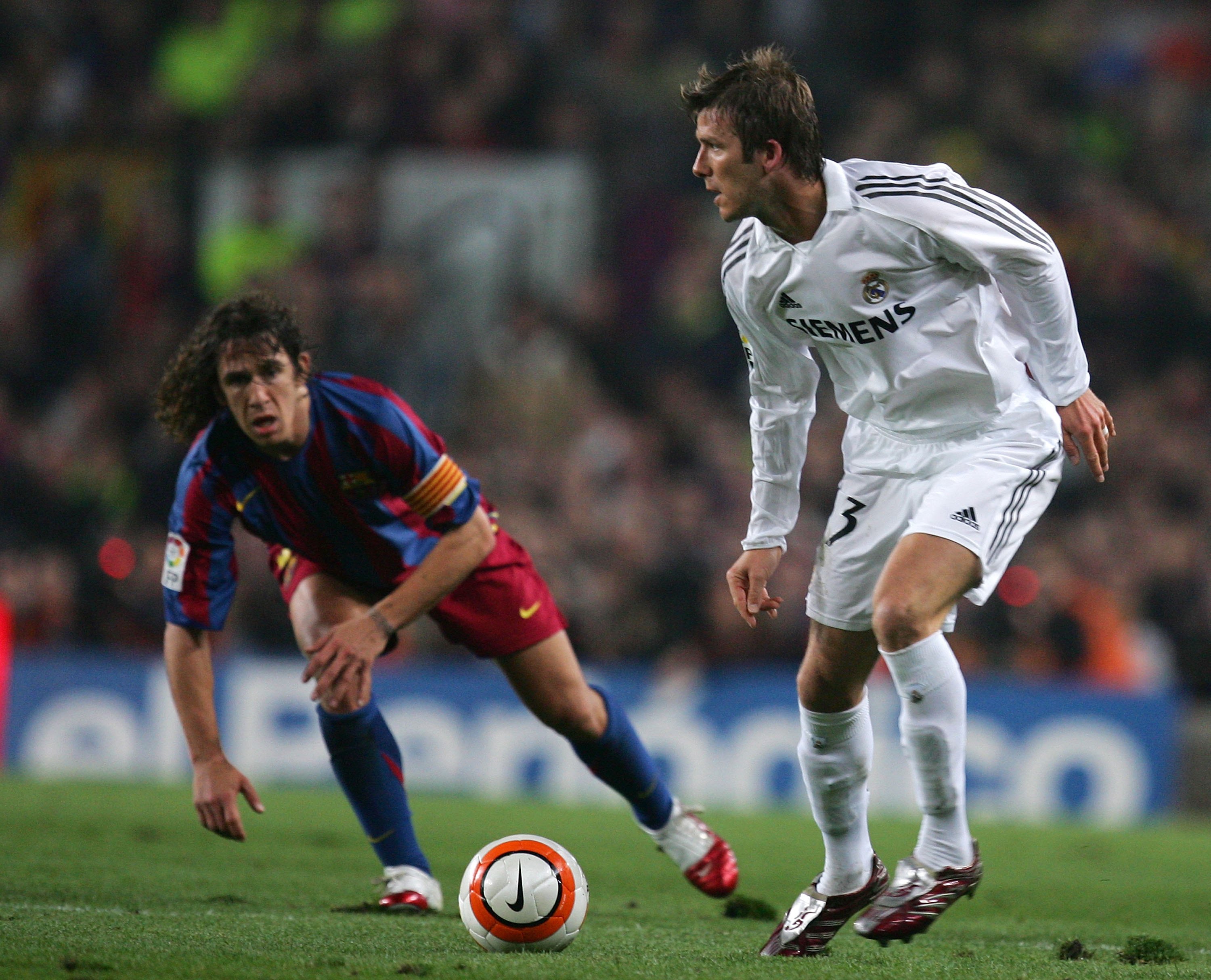 BARCELONA, SPAIN - APRIL 01: David Beckham (R) of Real Madrid is watched by Carles Puyol of Barcelona during a Primera Liga match at the Camp Nou stadium on April 1, 2006 in Barcelona, Spain. (Photo by Denis Doyle/Getty Images)