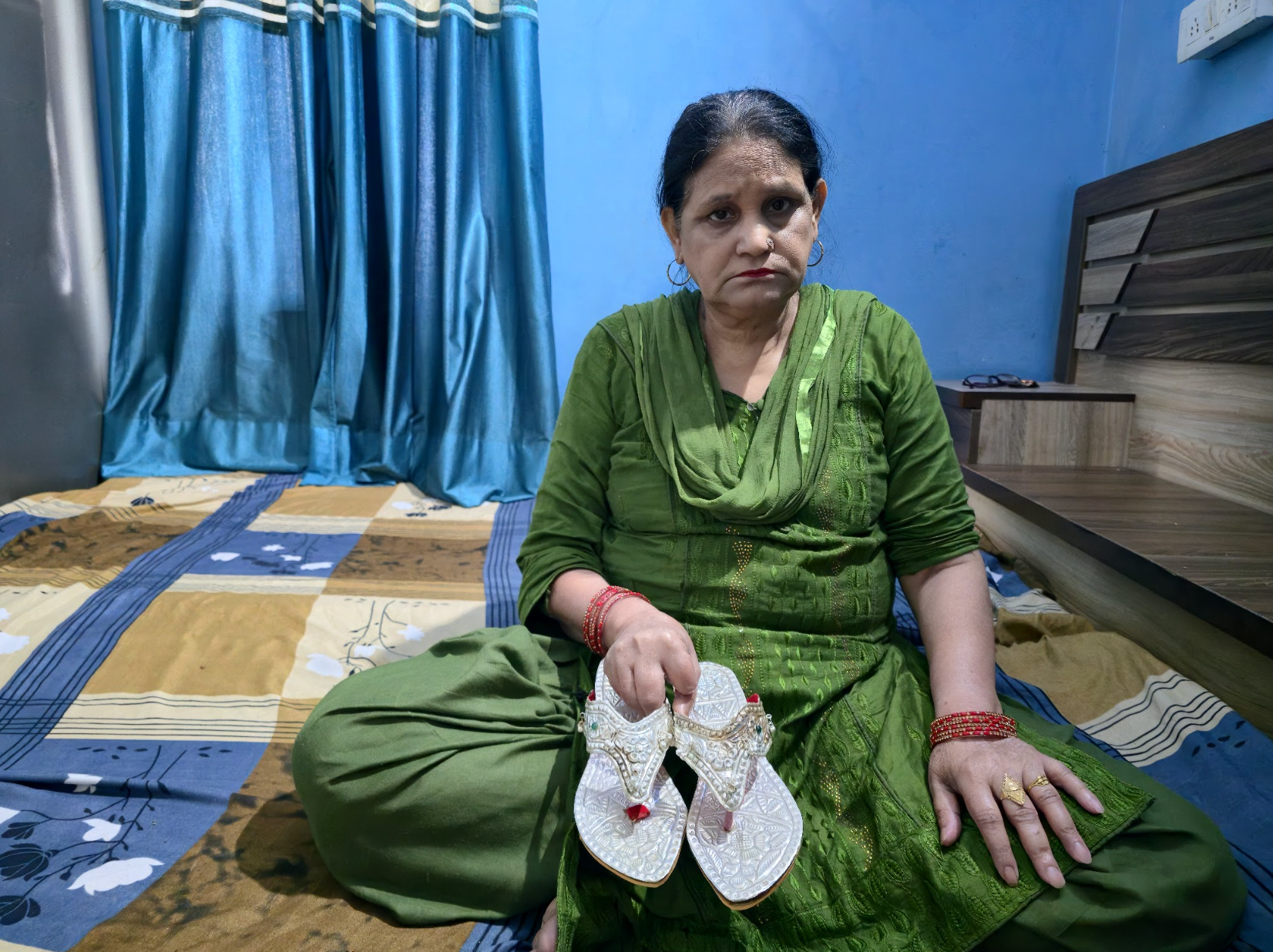 Naseem Jahan shows her five-decade-old silver nagras, among her most prized possessions, which she plans to pass on to her granddaughter amid soaring silver prices that have made a new pair unaffordable [Aatif Ammad/Al Jazeera]