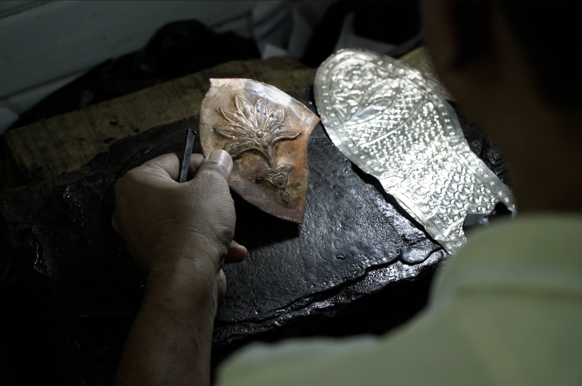 A nagra is being crafted, with the design hammered onto the reverse side of the silver sheet before it is fitted onto the shoe. [Aatif Ammad/Al Jazeera]