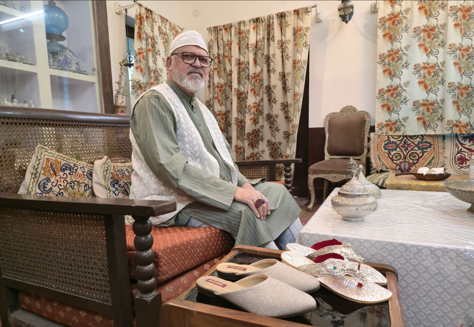 Nawab Abdullah Khan sits in his palace with the intricately designed nagras he and his wife wore at their wedding, which he says are the most antique pieces in his collection [Aatif Ammad/Al Jazeera]