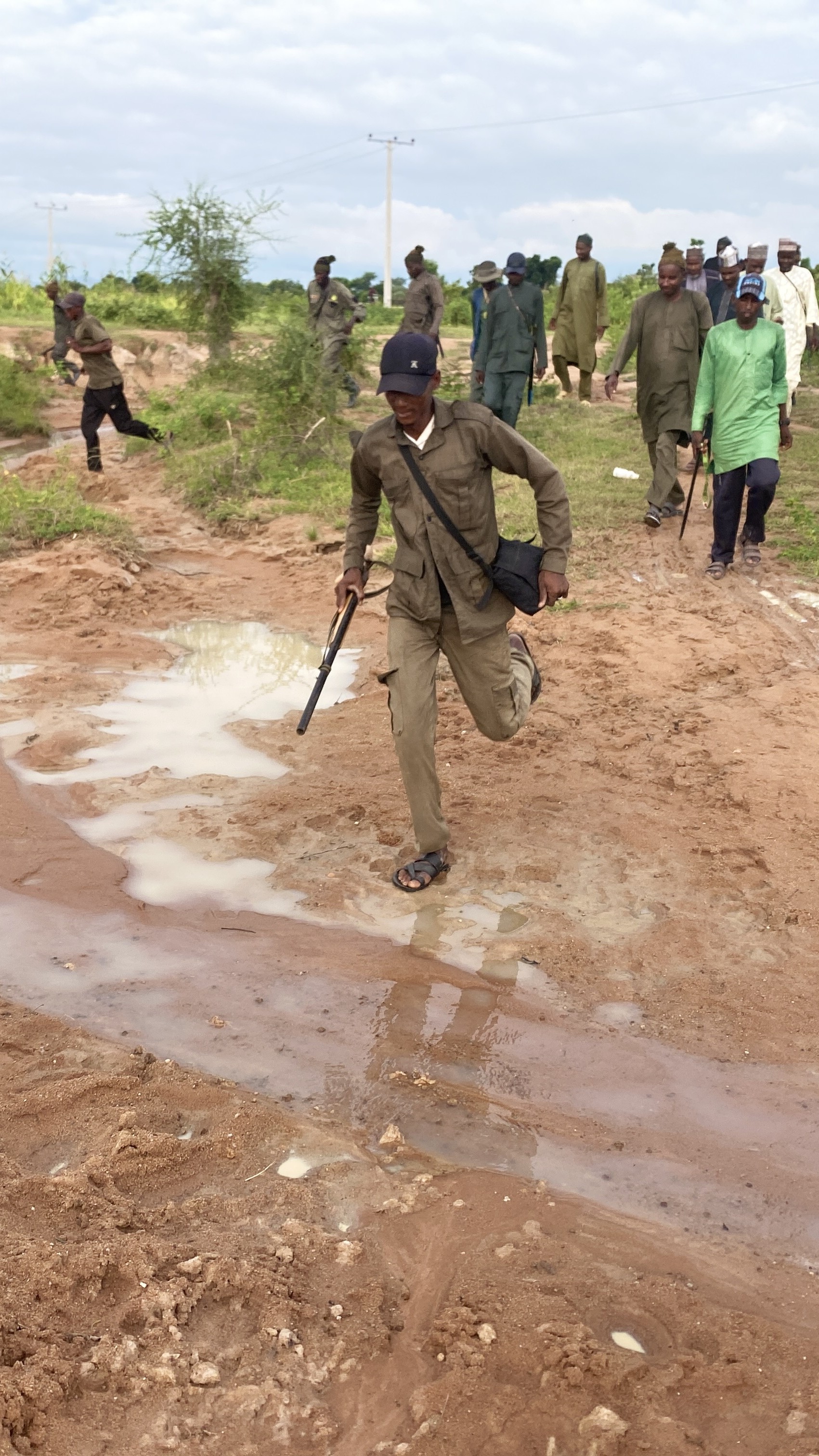 Men run across open terrain during a training exercise in Adamawa State, northeastern Nigeria