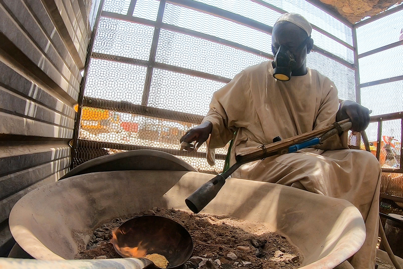 An artisanal miner burning gold in Dalago Market, Sudan [FILE: Mojahid Satti/Al Jazeera]