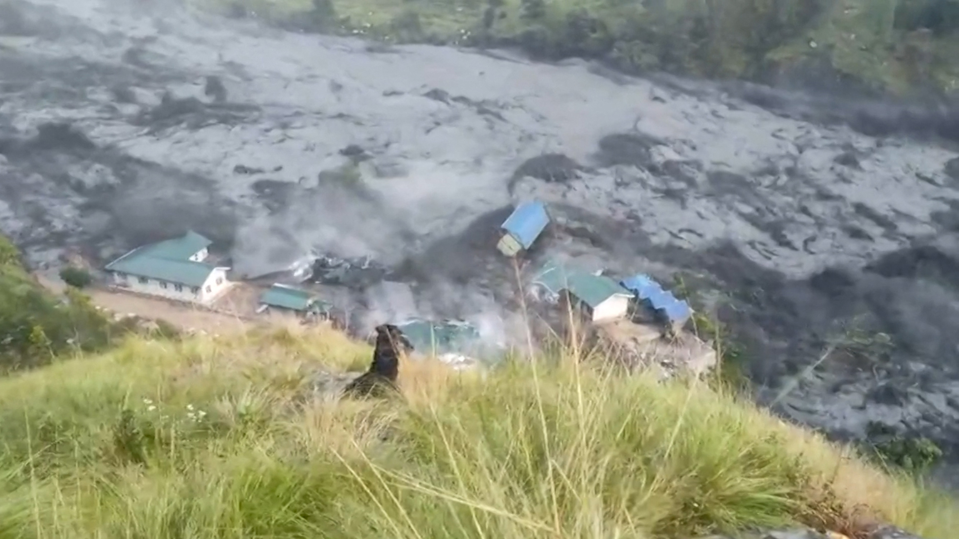 TOPSHOT - This video grab made from an AFPTV video taken on October 11, 2026 shows flood water destroying buildings along the Budhi Gandaki river, following a flash flood caused by a dry landslide, at Sallari Chumnubri in Nepal's Gorkha district on October 11, 2026.
