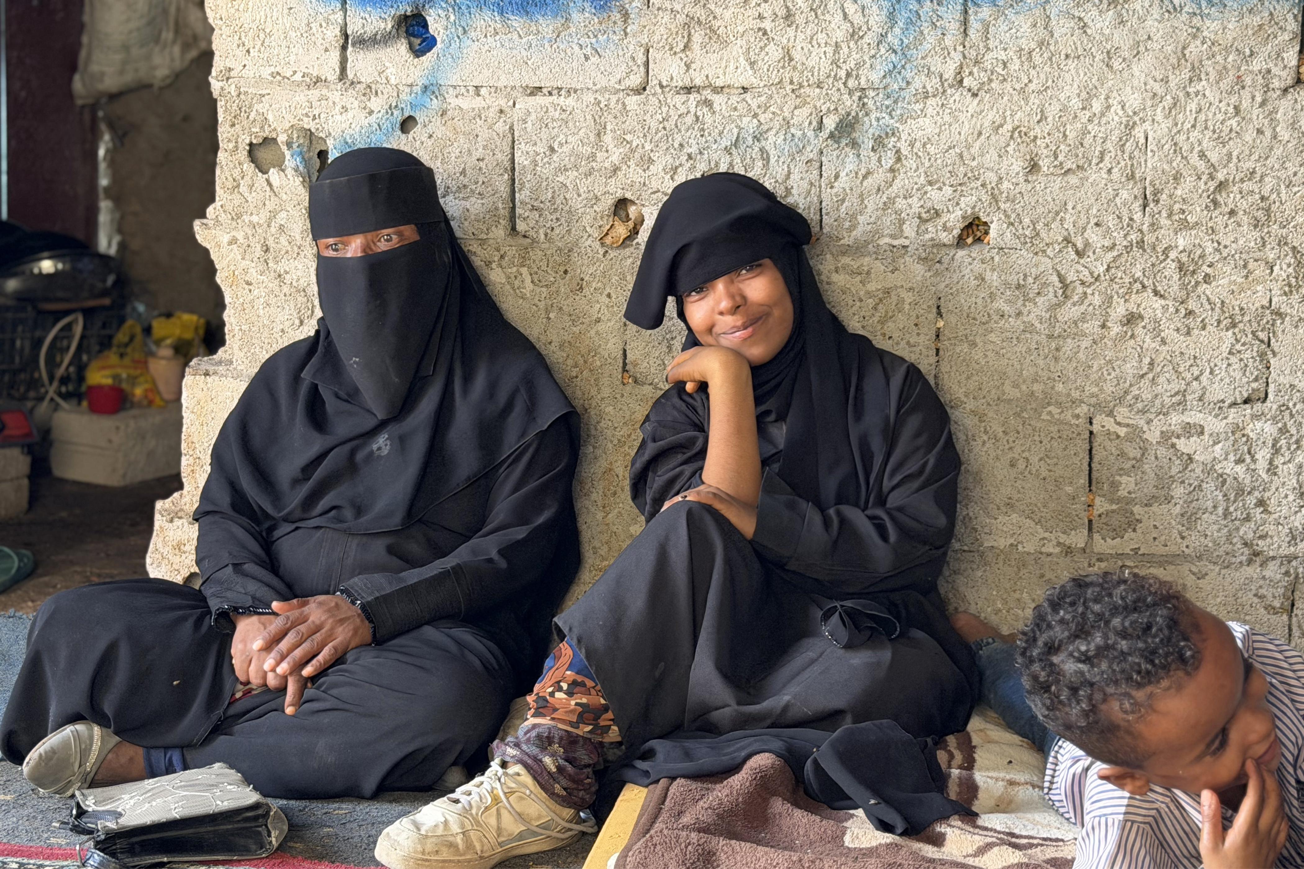 Members of a Yemeni family who were displaced from their homes with their families due to renewed clashes between Yemen’s Saudi-backed government forces and the Houthis sit in a shop used as temporary shelter in Taiz province in southwestern Yemen on October 8, 2026 [AFP]