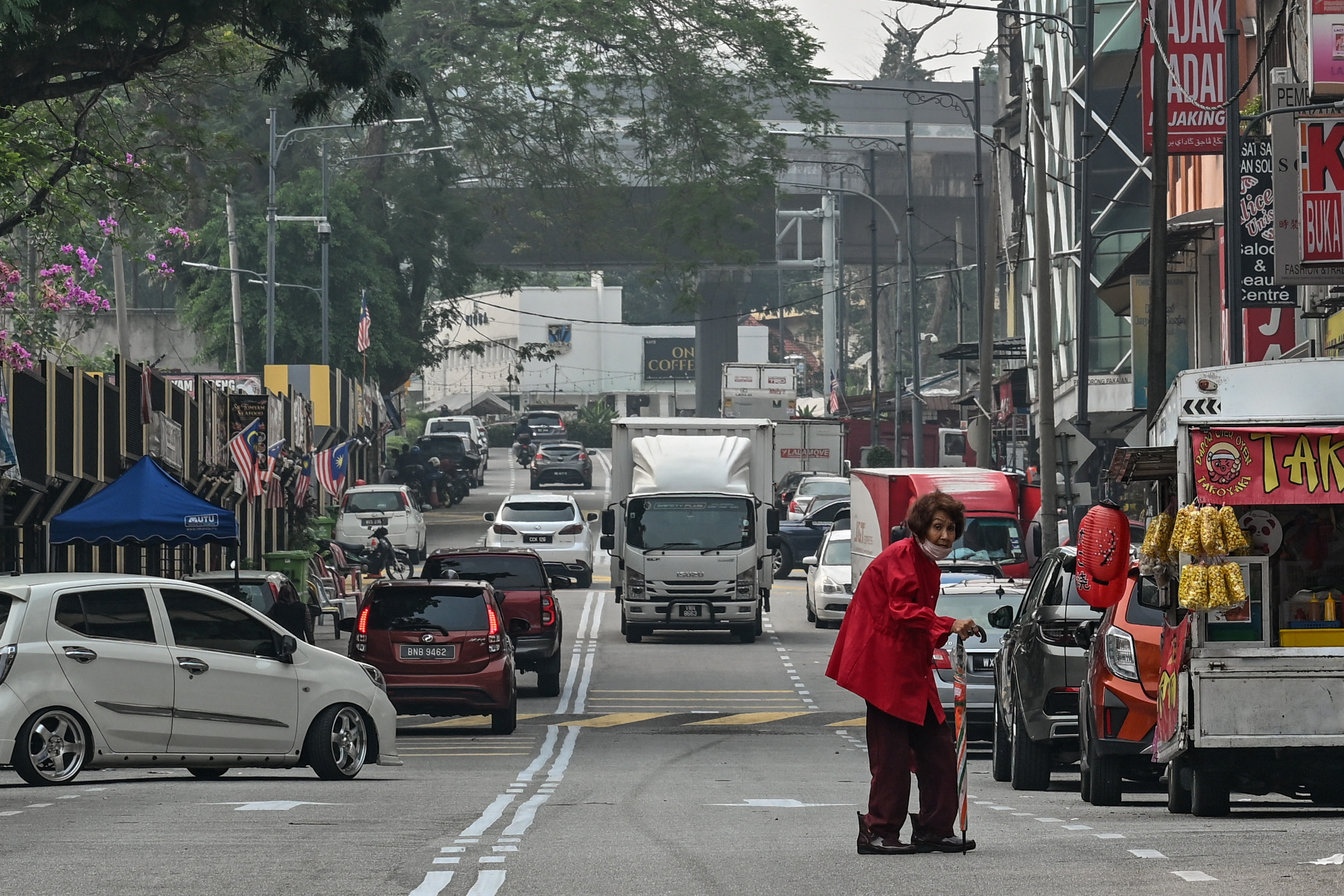 A woman wearing a face mask walks along a street in Kuala Lumpur as Malaysia continues to be shrouded in haze caused by fires in Indonesia