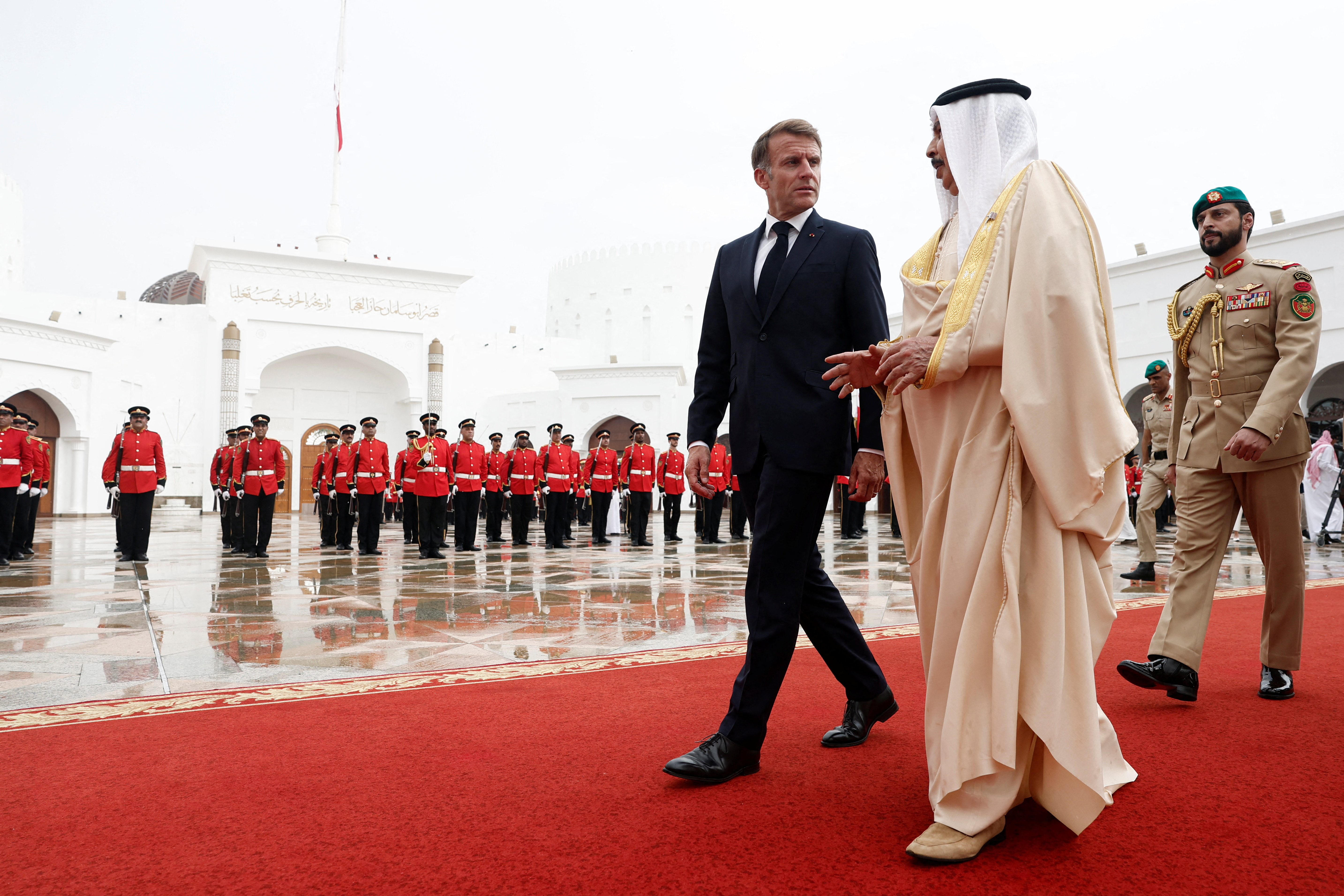 TOPSHOT - Bahrain's King Hamad bin Isa al-Khalifa (R) welcomes France's President Emmanuel Macron at al-Sakhir Palace, near Zallaq, on October 20, 2026.