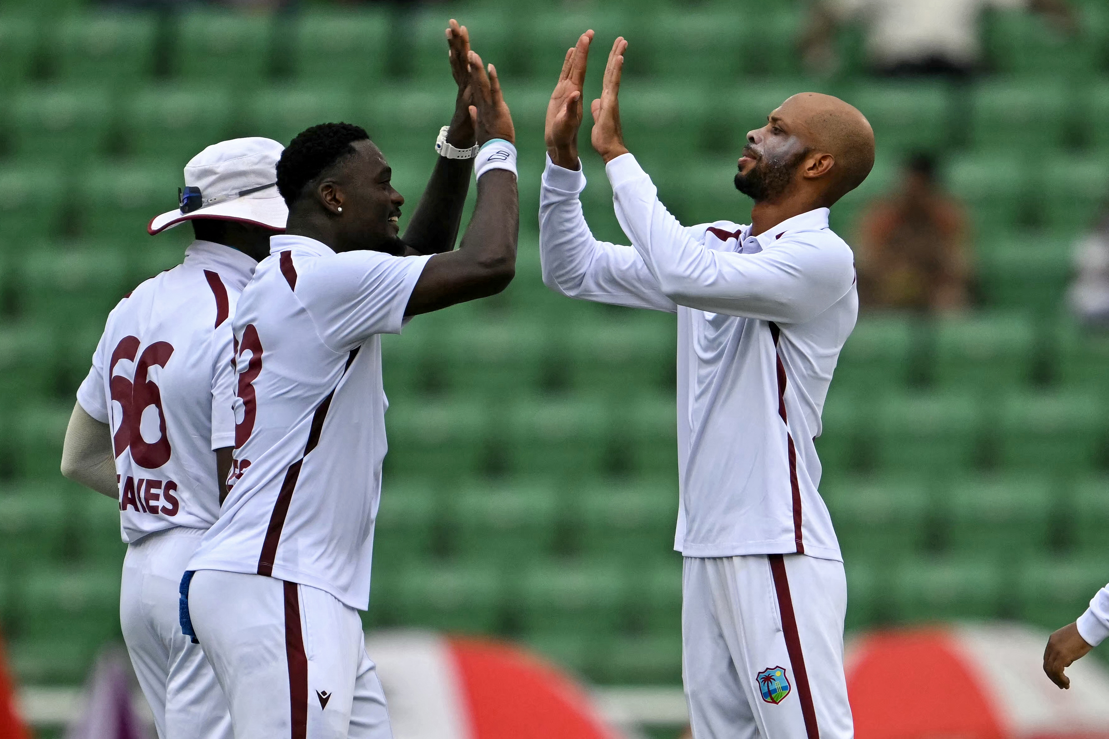 West Indies' captain Roston Chase (R) celebrates with teammates after taking the wicket of Bangladesh's Towhid Hridoy during the third day of the first test cricket match between Bangladesh and West Indies at the Sher-e-Bangla National Stadium in Mirpur on October 30, 2026. (Photo by Salahuddin Ahmed / AFP)