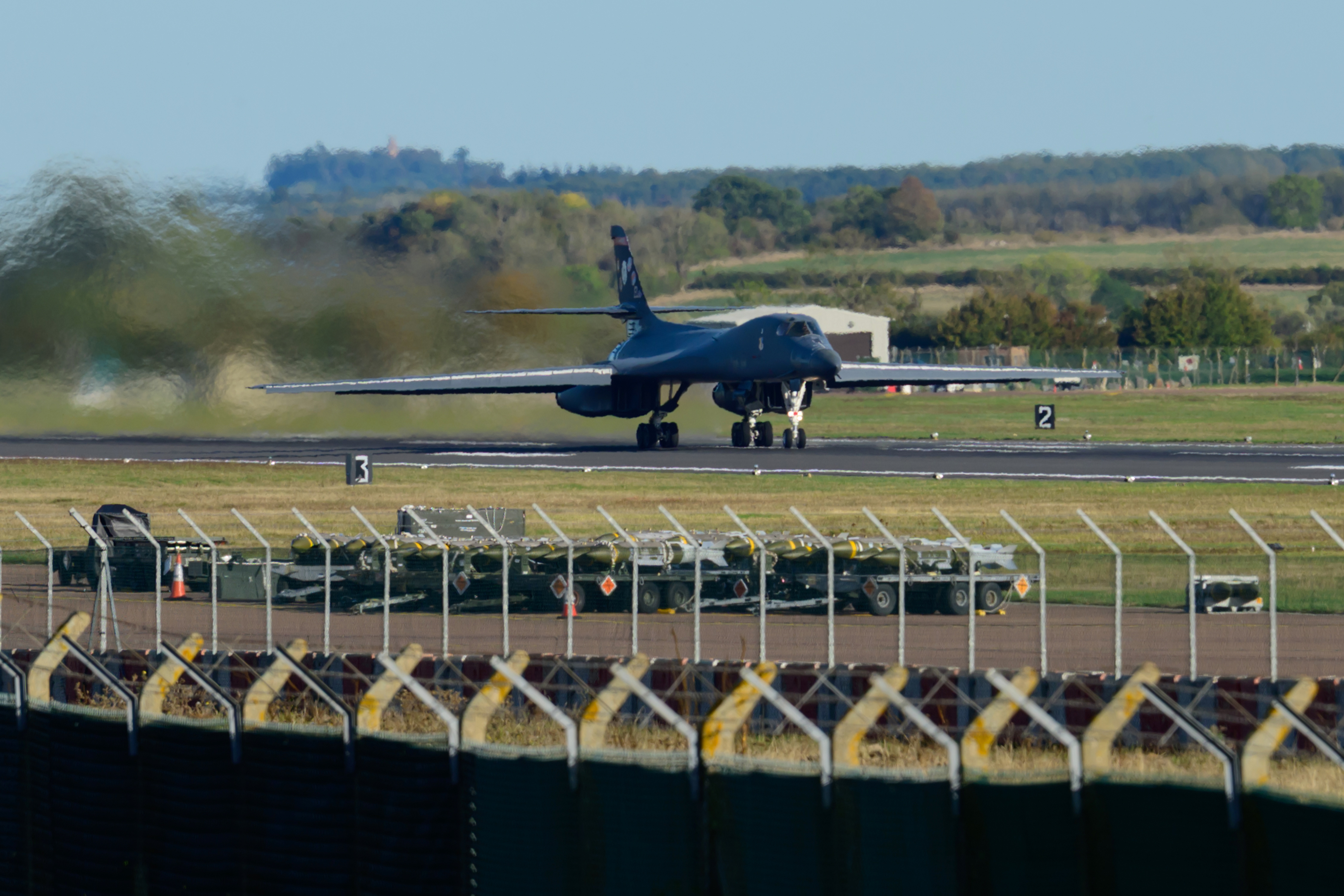 FAIRFORD, ENGLAND - OCTOBER 4: Munitions sit beside runway 27 as a Rockwell B1 Lancer heavy bomber departs for home at RAF Fairford on October 04, 2026 in Fairford, United Kingdom. Around a dozen US B-1B Lancer bombers remain stationed at RAF Fairford in Gloucestershire, following a significant military drawdown late last month that saw six B-52 Stratofortress bombers return across the Atlantic. The heavy aircraft are part of an American forward strike force that has used the Gloucestershire airfield to conduct missions against Iranian capabilities, with total aircraft numbers at the Gloucestershire hub previously peaking between 21 and 23 strategic bombers earlier this year. (Photo by David Bown/Getty Images)