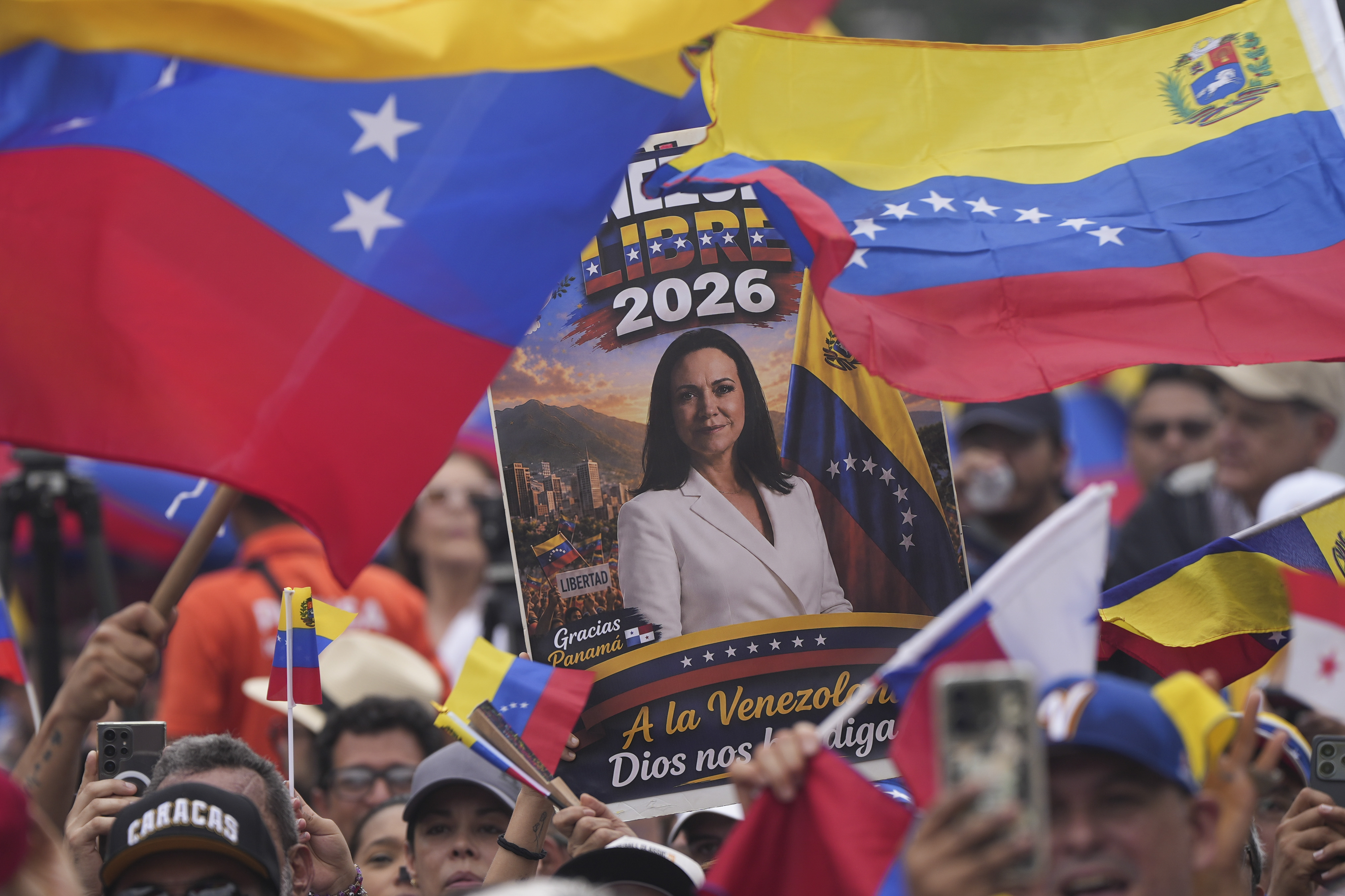 PANAMA CITY, PANAMA - MAY 23: People hold signs and Venezuelan flags in support of Maria Corina Machado during a gathering of Venezuelans in Panama on May 23, 2026 in Panama City, Panama. Venezuelan opposition leader and Nobel Peace Prize María Corina Machado arrived to Panama as part of an international tour to hold bilateral meetings with the nation's authorities and the Venezuelan diaspora. During her stay in Panama, Machado stated that she will run for president in a "Clean and Free" election process. (Photo by Enea Lebrun/Getty Images)