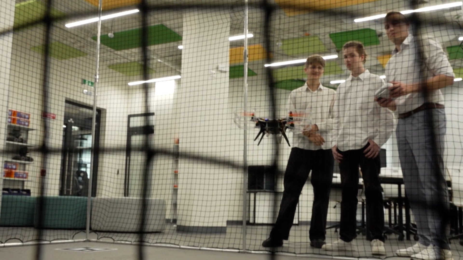 Children at school flying a drone inside as a class