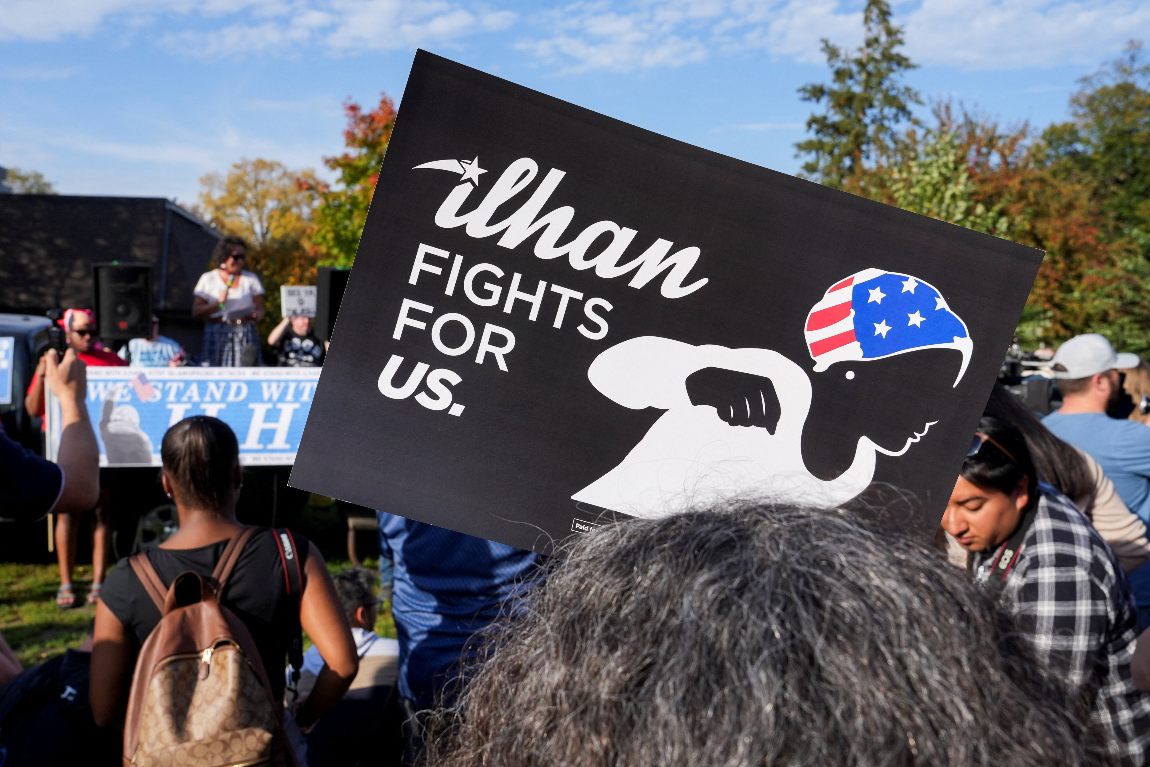 A person holds a placard, as Minnesota State Senator Mary K. Kunesh (DFL-MN) speaks during a rally of supporters of Democratic US Representative Ilhan Omar of Minnesota after federal authorities conducted a predawn raid on Omar’s Washington, DC-area home, in Minneapolis, Minnesota, US, October 12, 2026. REUTERS/Tim Evans