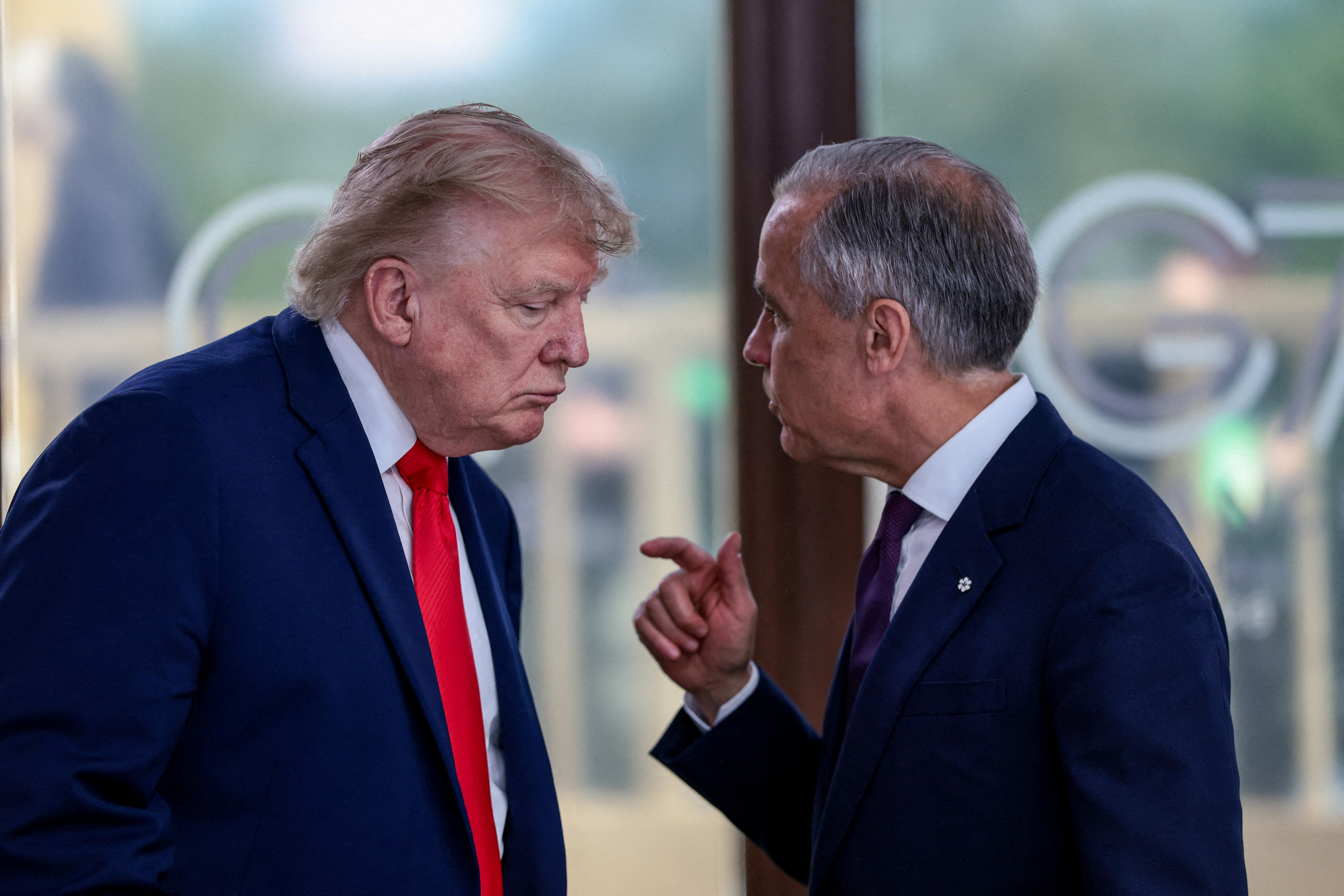 FILE PHOTO: U.S. President Donald Trump speaks with Canadian Prime Minister Mark Carney at a working lunch with leaders of G7 and the Middle East, in Evian-les-Bains, France, June 16, 2026. REUTERS/Evelyn Hockstein/Pool/File Photo