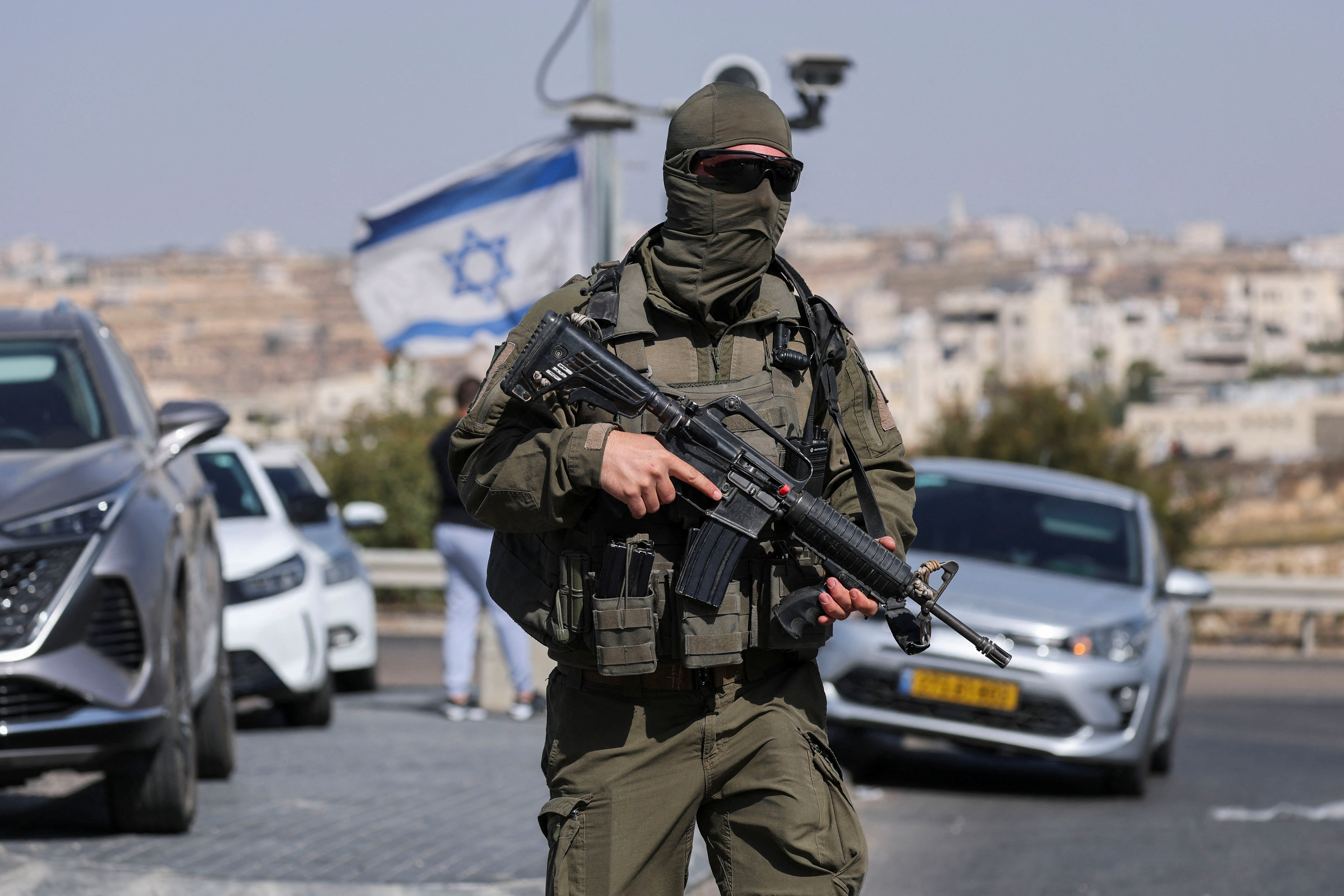 A member of Israeli forces stands guard near a shooting scene in Hebron in the Israeli-occupied West Bank October 23, 2026. REUTERS/Ammar Awad