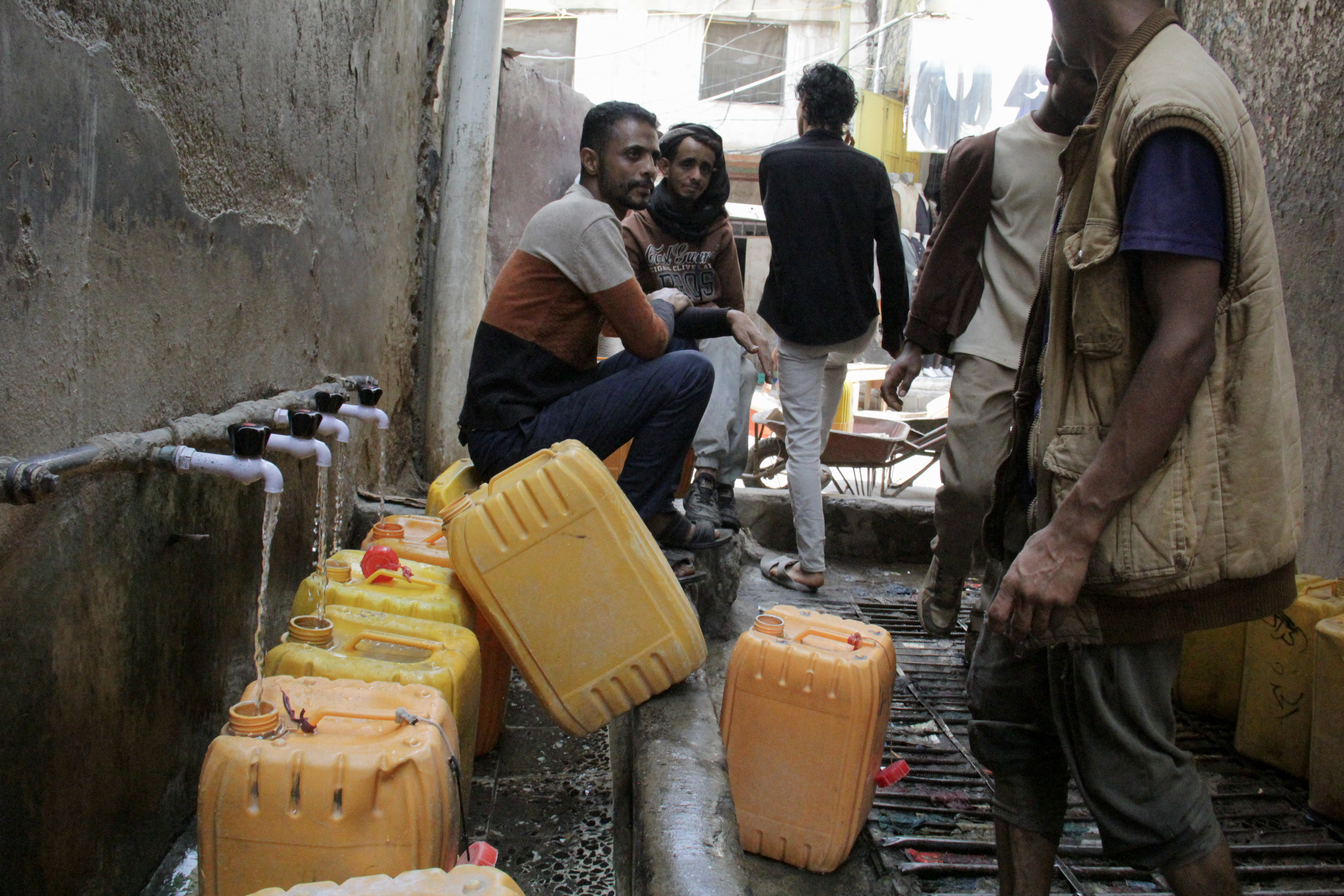 People fill jerrycans with drinking water from a charity tank in the southwestern city of Taiz, Yemen October 21, 2026. REUTERS/Anees Mahyoub