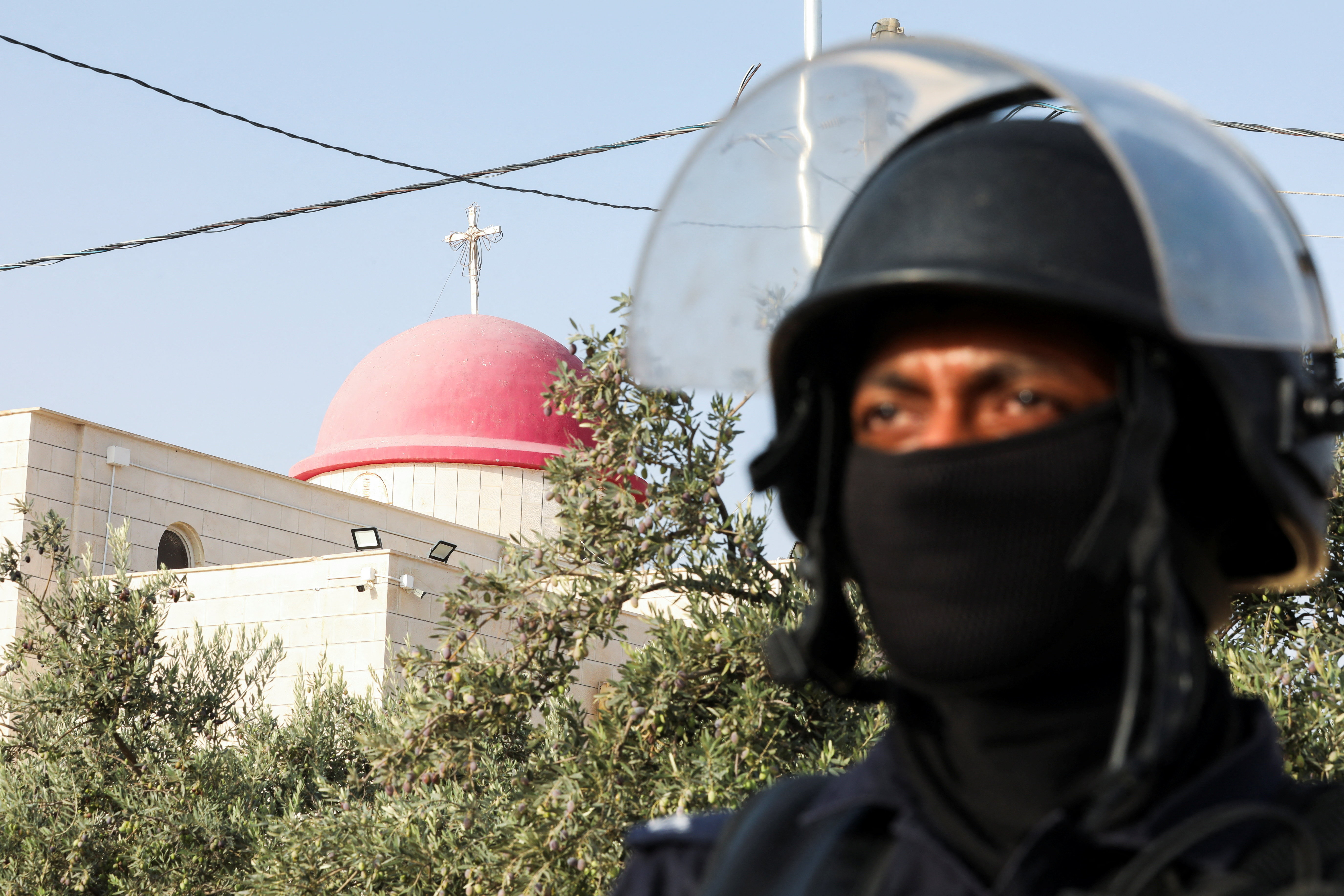 A member of security personnel stands outside Saint George’s Greek Orthodox Church, where gunmen opened fire during a funeral the previous day, in the village of Hamoud, Karak, Jordan, October 24, 2026. REUTERS/Alaa Al Sukhni