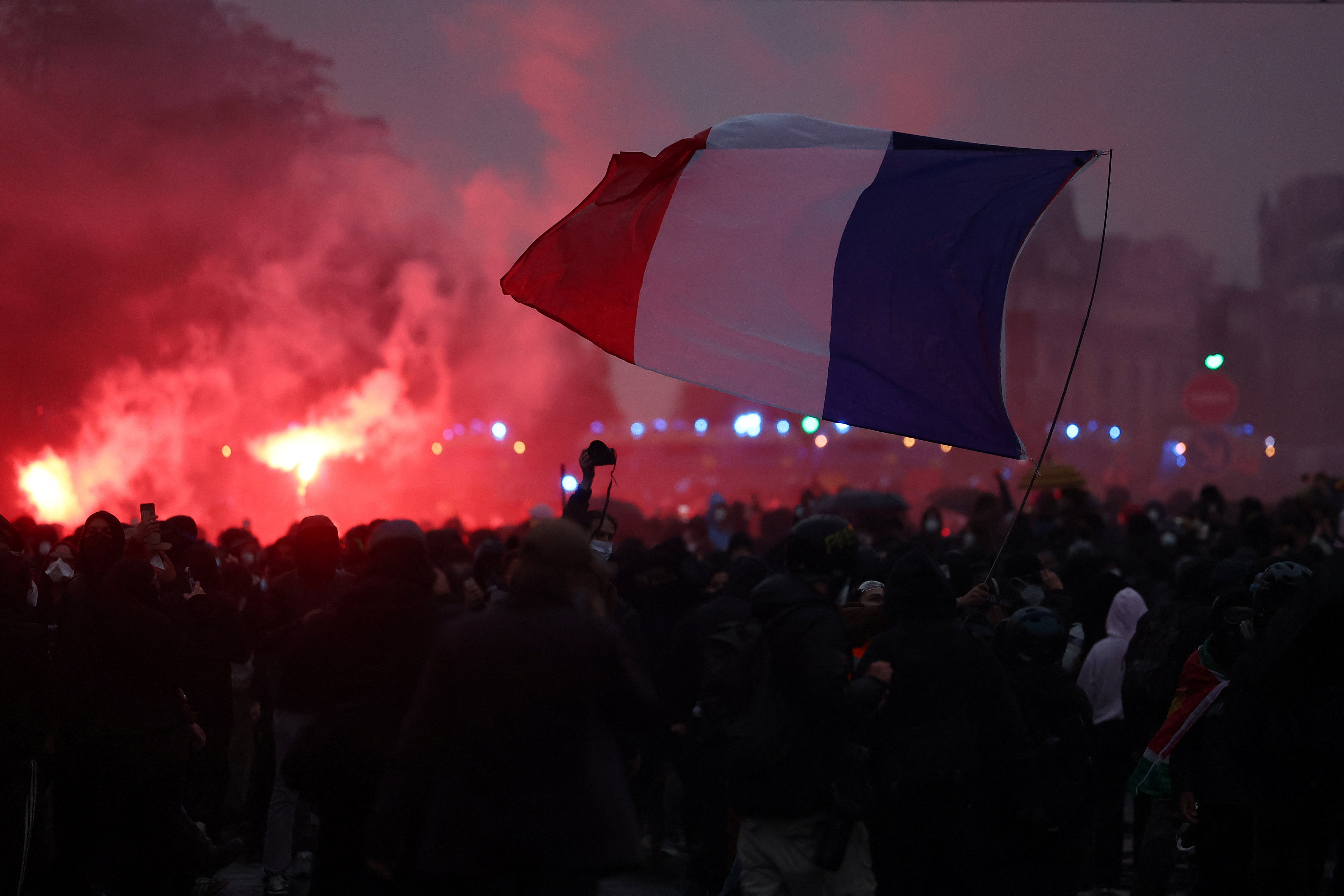 Protesters hold a French flag amid clashes during demonstration organised by labour unions in Paris as part of nationwide protests called by the "Yellow Vests" movement joined by French high school and university students against the cost of living and rising fuel prices, in France, October 24, 2026. REUTERS/Abdul Saboor