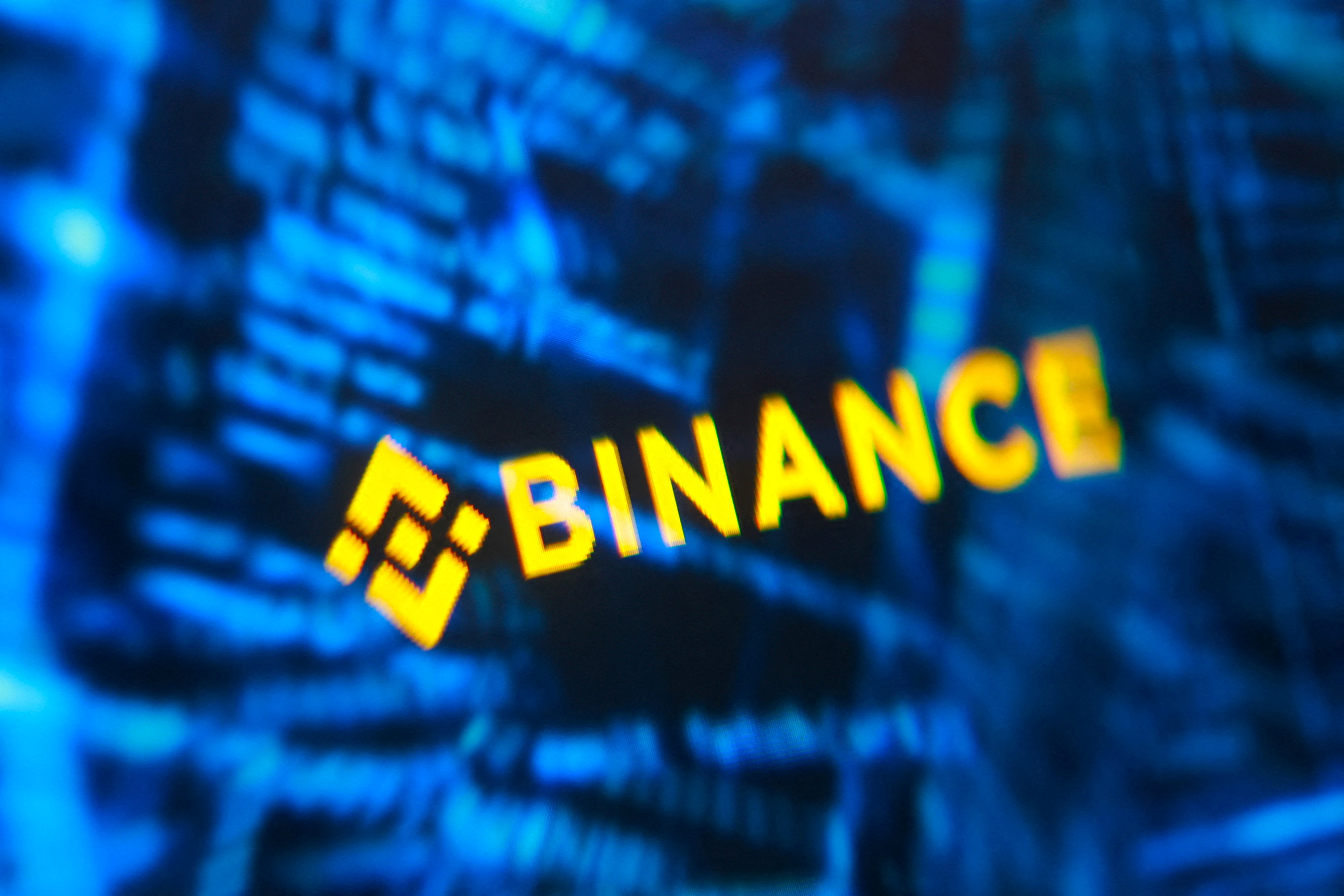 Binance logo and hacker code are seen in an illustration.