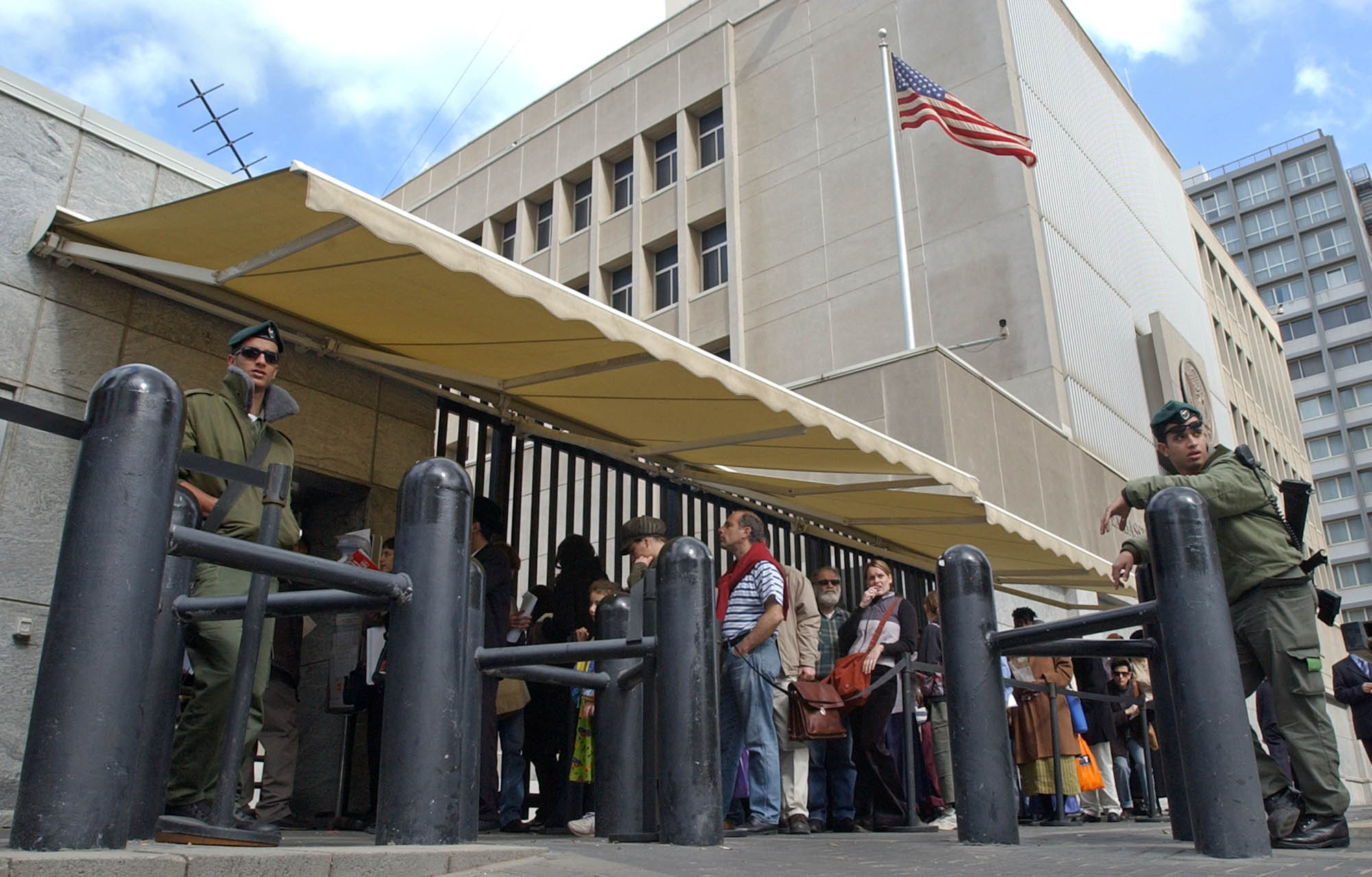 Israeli border policemen guard the U.S. Embassy in Tel Aviv, as other Israelis line up for U.S. visas Monday, March 17, 2003. The U.S State Department ordered non-essential U.S diplomats and embassy staff to leave Israel, Kuwait and Syria Sunday, and urged U.S citizens to leave due to the threat of war with Iraq. (AP Photo/Eitan Hess-Ashkenazi)